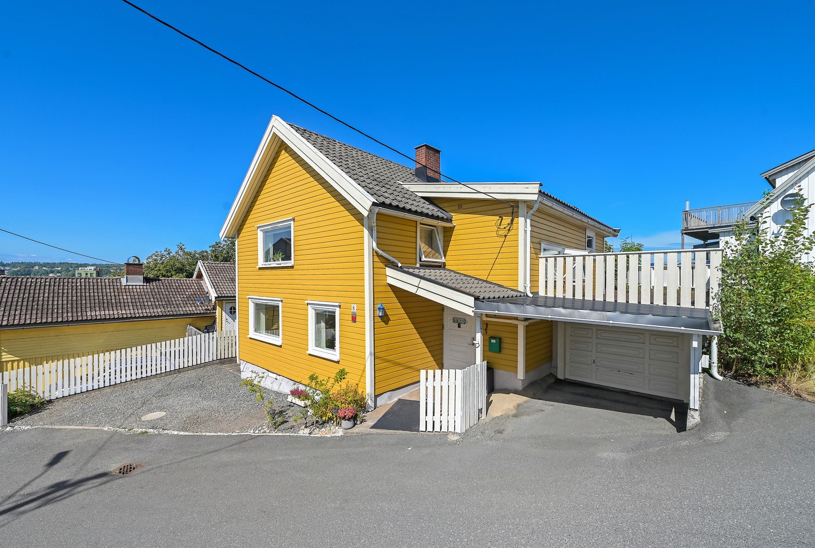 Tomten er opparbeidet med noe beplantning, ellers bebyggelse. Galleribilde