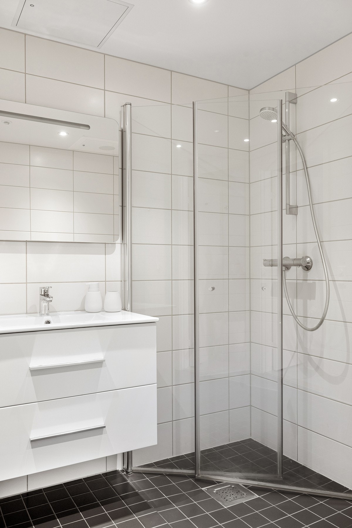 Badet er innredet med en innredning med nedfelt servant, toalett og innfellbare dusjvegger som gir en plassbesparende og stilren løsning til badet. Galleribilde