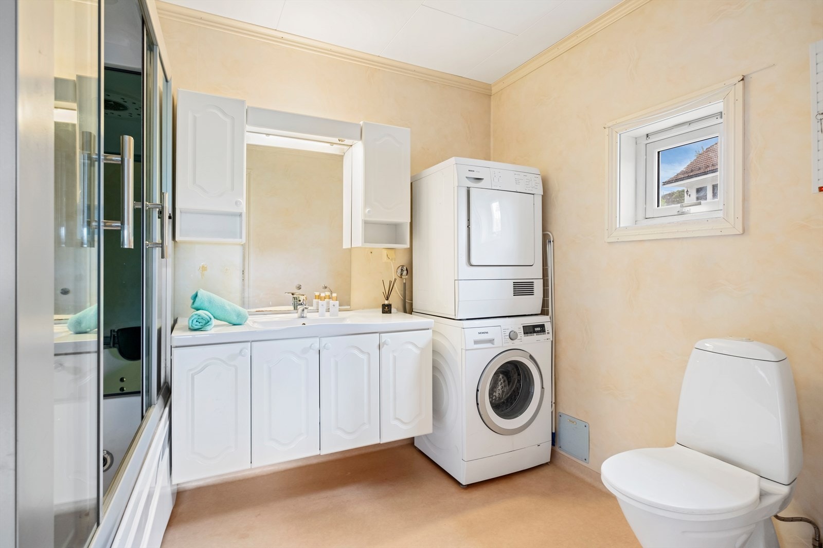 Bad/vaskerom har våtromstapet/belegg på vegger. Taket har himlingsplater. På gulv er det belegg og det er varmekabler i gulvet. Rommet har innredning med nedfelt servant, toalett og dusjkabinett som også fungerer som badekar. Galleribilde