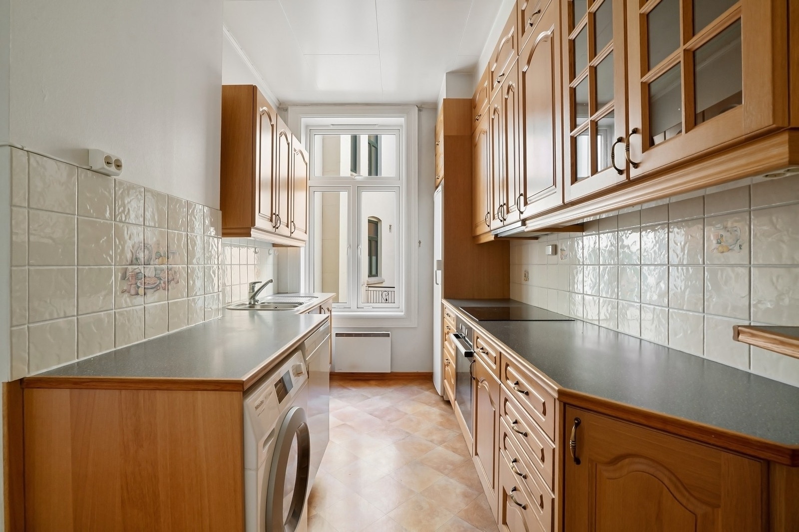 Separat kjøkken med opplegg for vaskemaskin. Integrert induksjonstopp og stekeovn, samt kullfilterventilator. Galleribilde