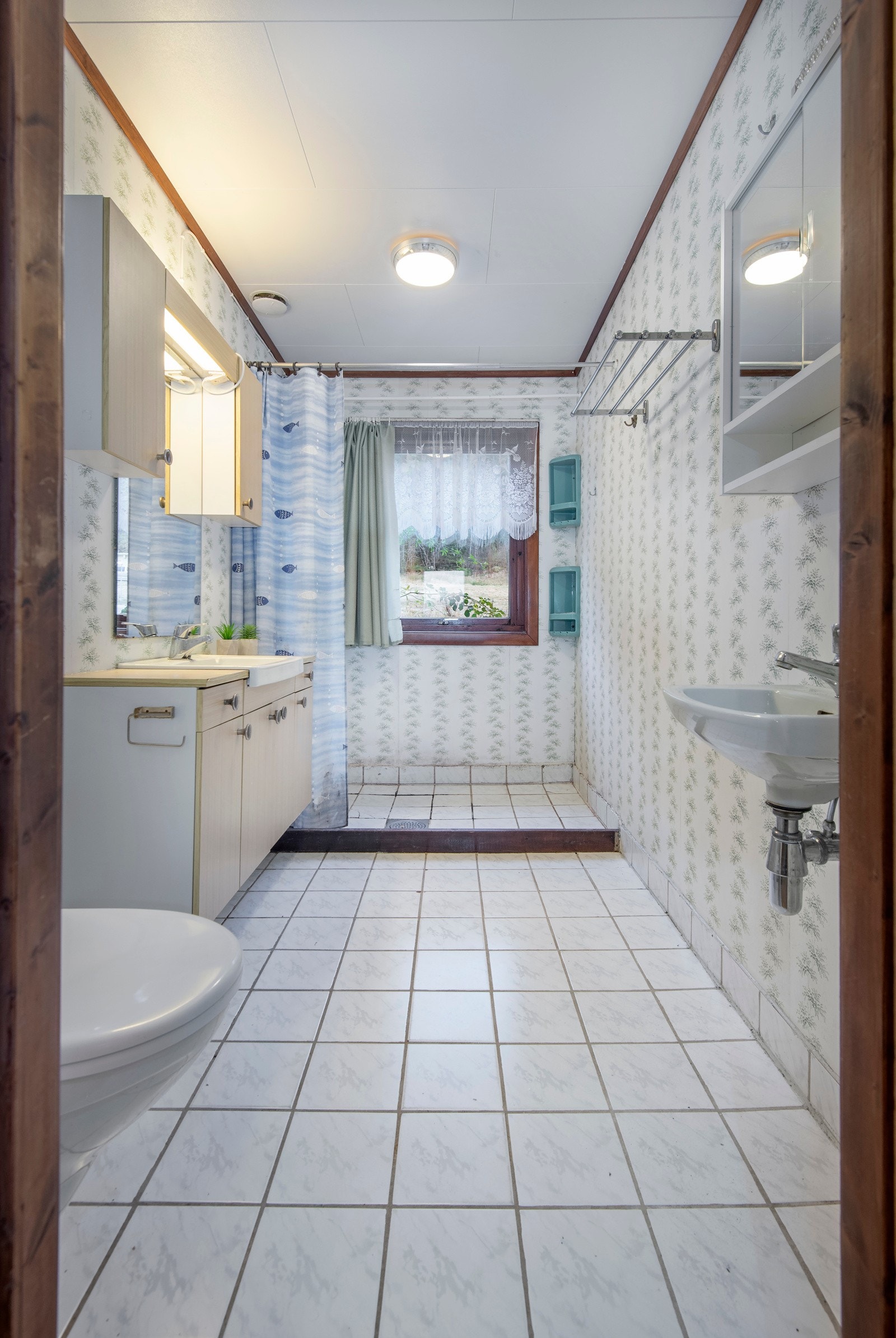 Badet er fra byggeår. Det er fliser på gulvet med kantflis. På veggene er det baderomstapet. Galleribilde