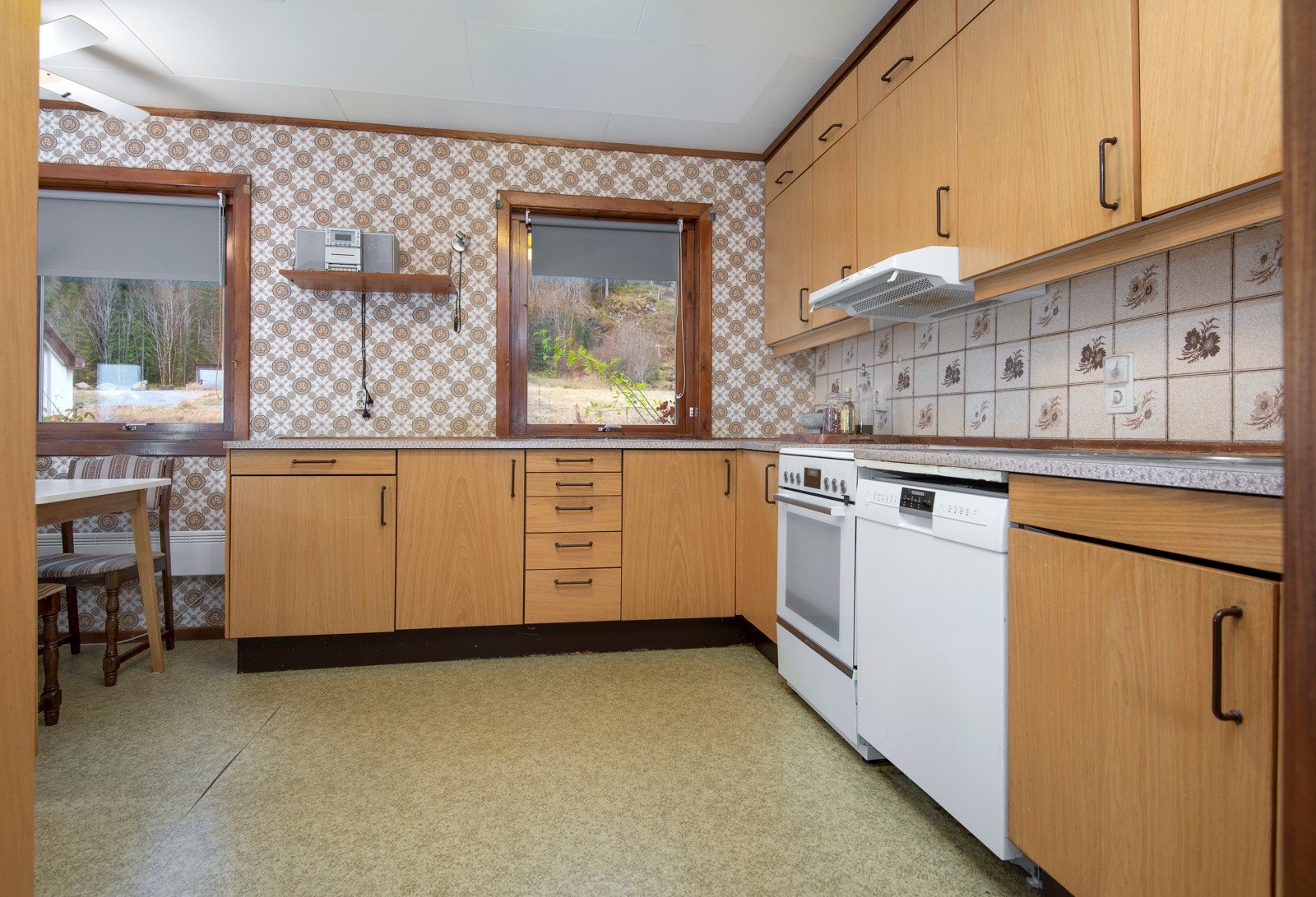 Kjøkkkeninnredning med finerte lyse fronter og laminat benkeplate. Galleribilde