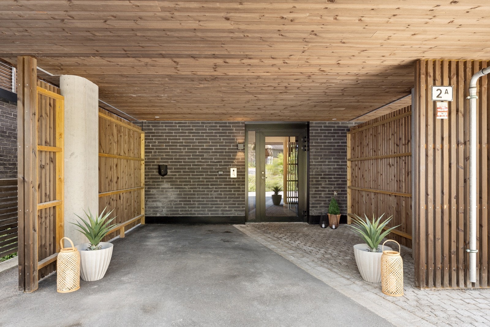 Overbygget inngangsparti med privat carport med el-billader. Galleribilde