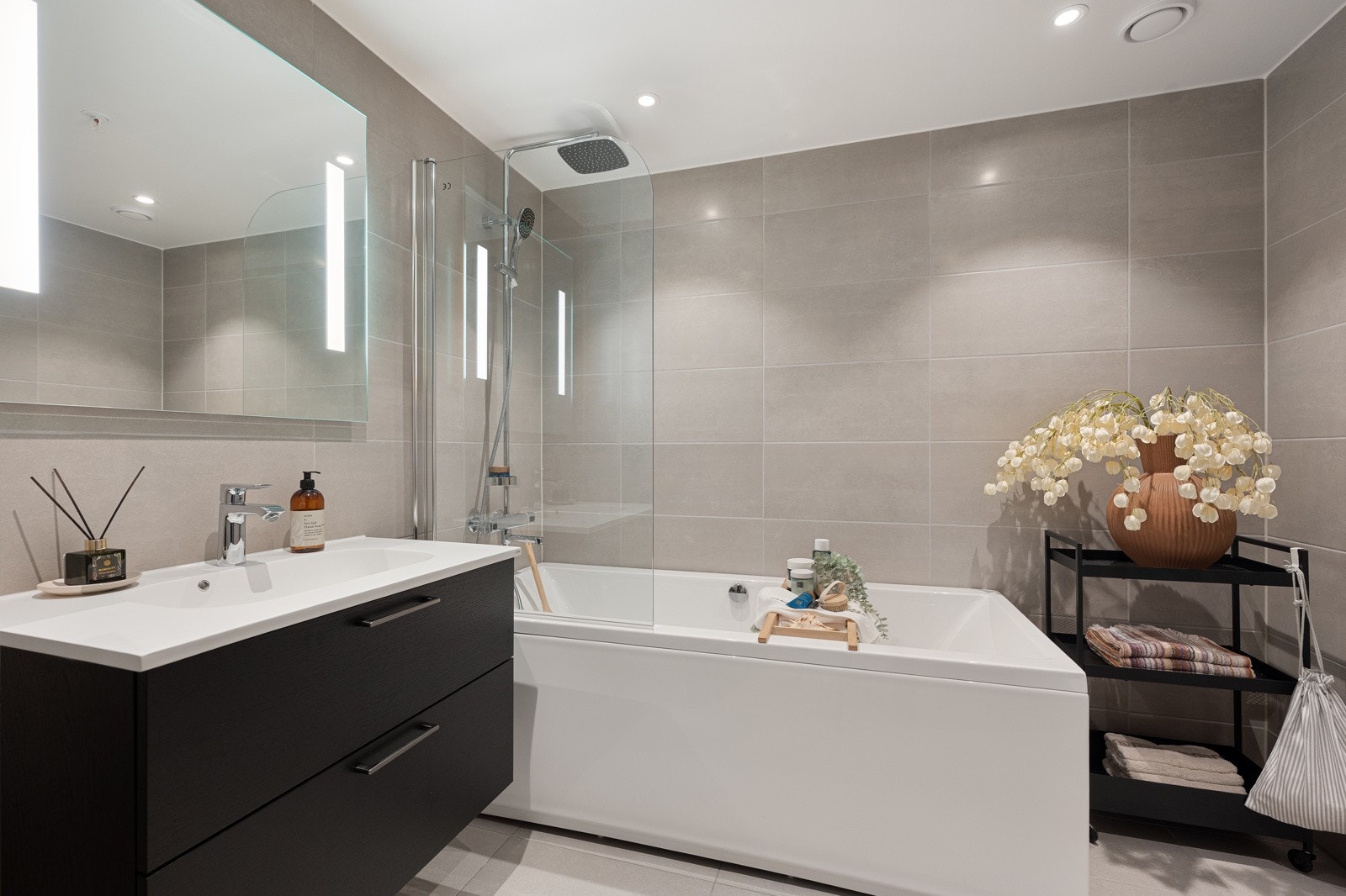 Bad 1: Stort flislagt bad med innredning fra HTH. Badekar og regnfallsdusj. Galleribilde