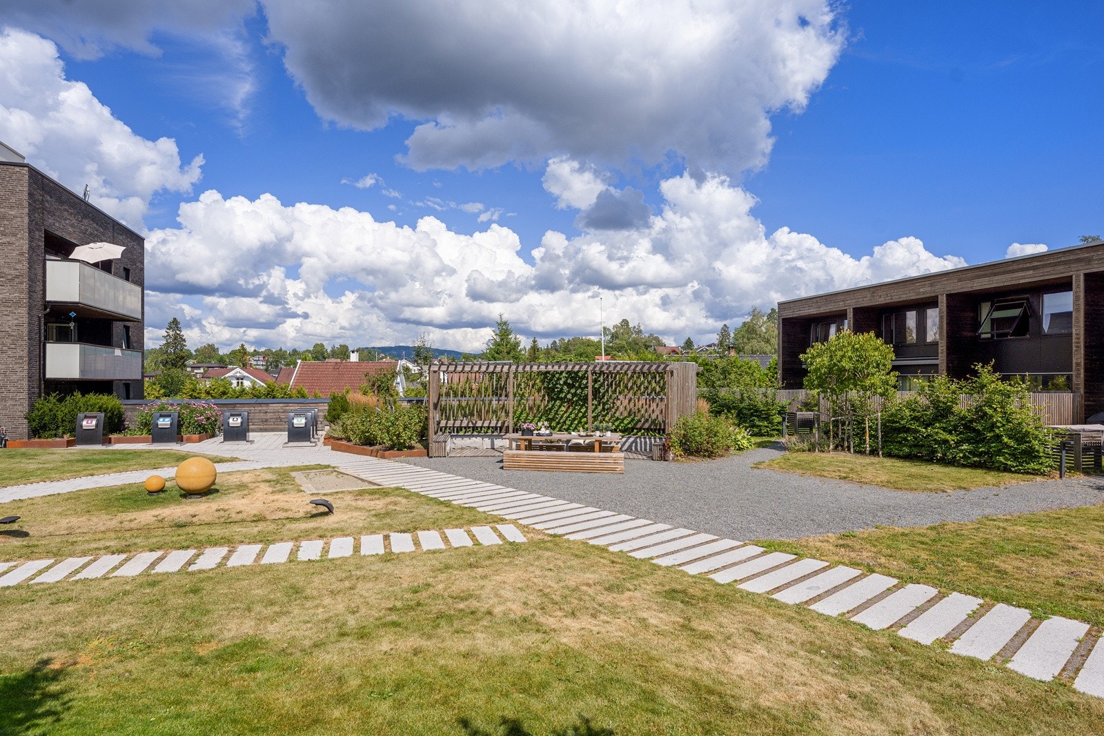 Inngjerdet felles atriumshage med lekeapparater og bærbusker Galleribilde