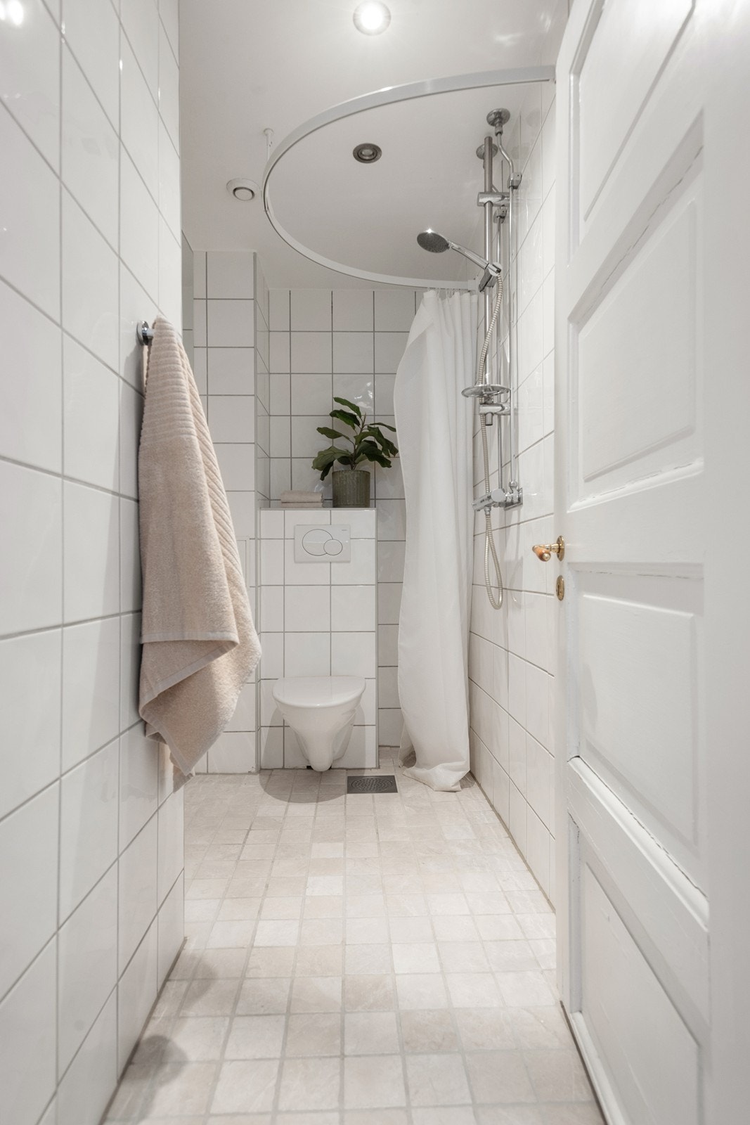 Stilrent og flislagt bad med gulvvarme og downlights Galleribilde