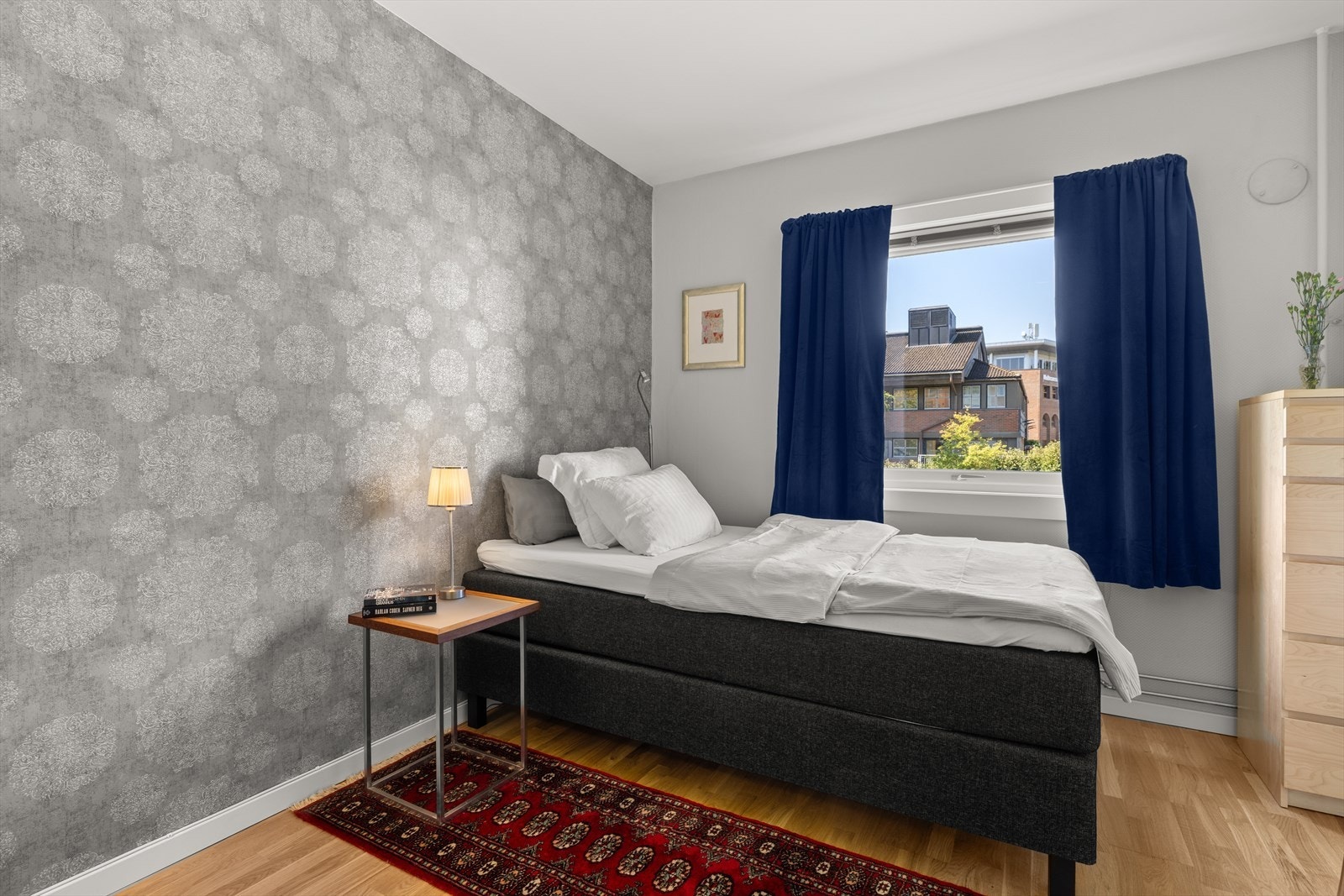 Romslig soverom med plass til stor dobbeltseng og tilhørende nattbord Galleribilde