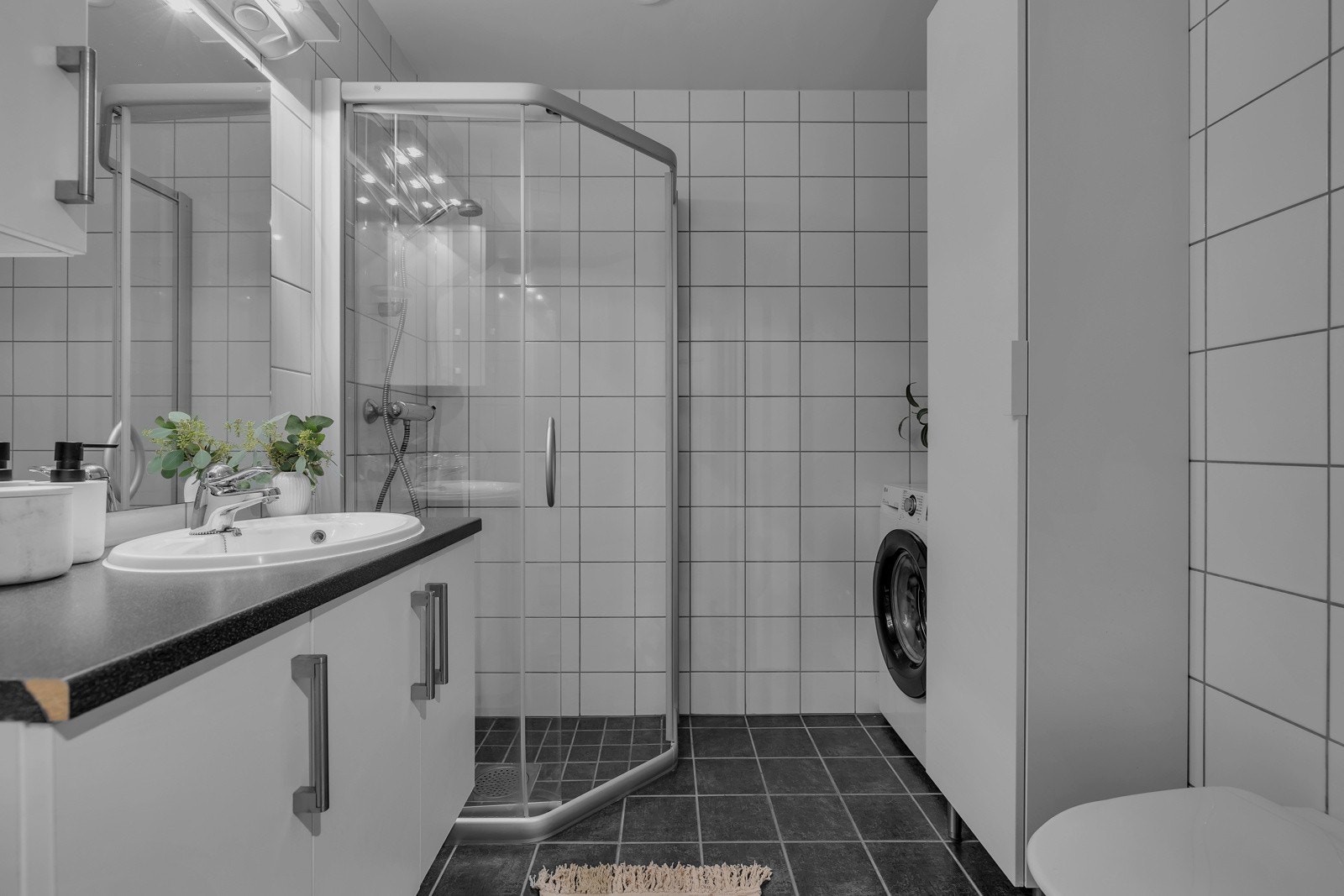 Flislagt bad med dusjhjørne, opplegg til vaskemaskin, wc og servant med over/underskap. Galleribilde