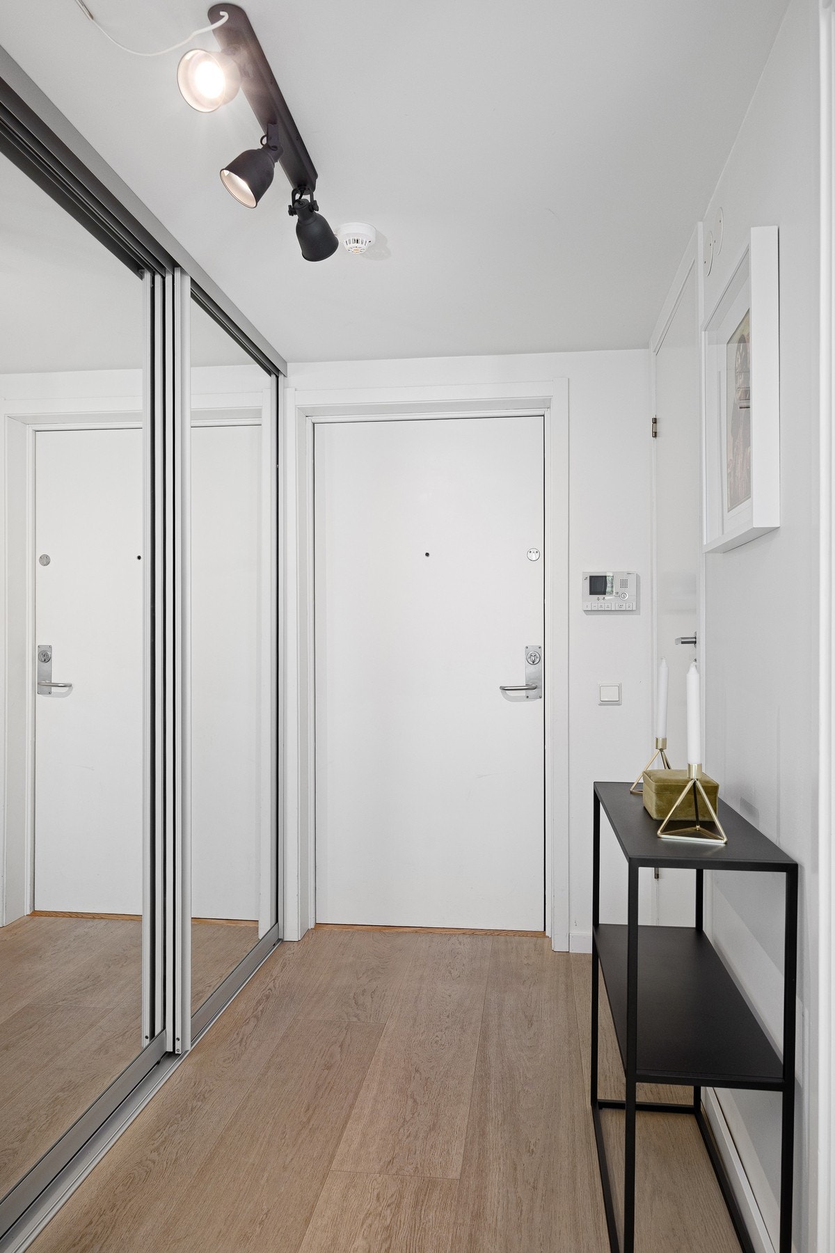 Lys og praktisk entré med gode oppbevaringsmuligheter i stor skyvedørsgarderobe med speilfronter. Galleribilde