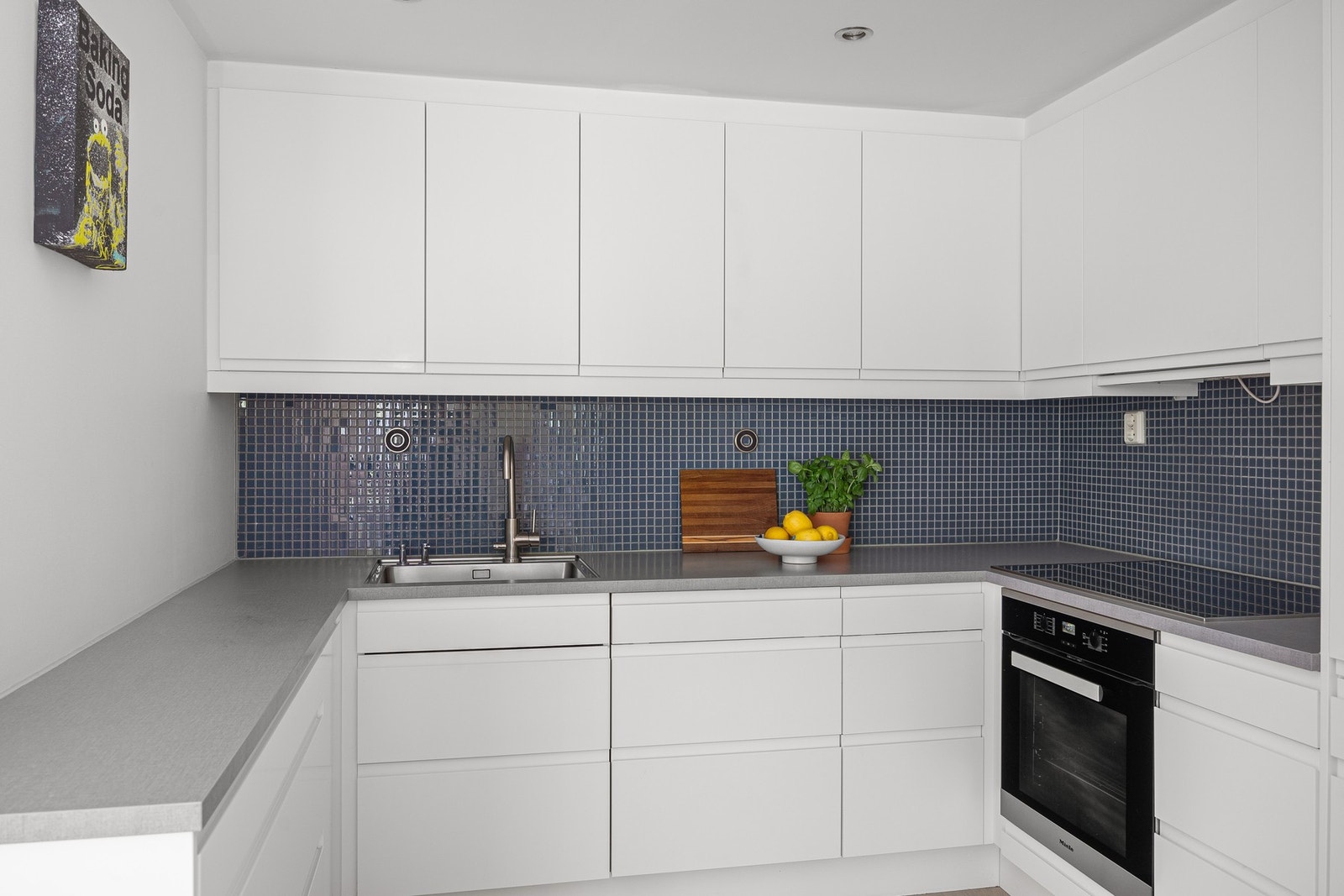 Stilren takhøy kjøkkeninnredning med integrerte hvitevarer og godt med skap- og benkeplass. Galleribilde