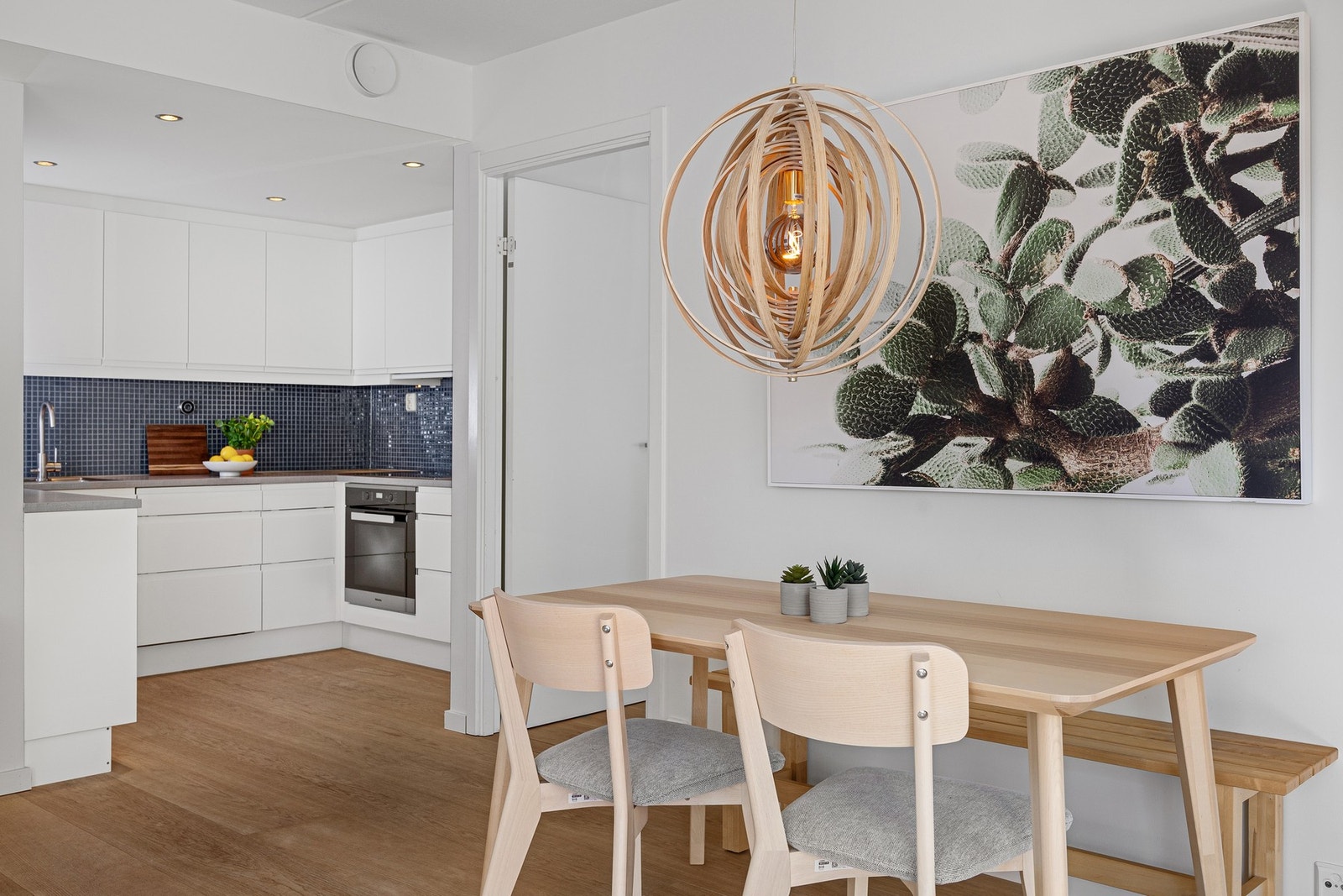 Delvis åpen stue- og kjøkkenløsning med kjøkkeninnredning i egen sone. Galleribilde