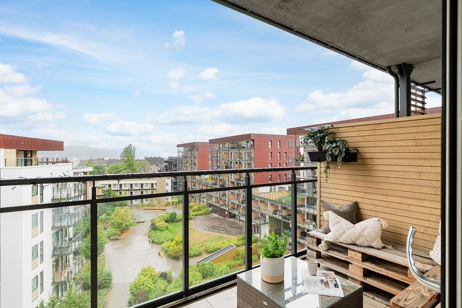 Balkongen er på 12 kvm og er overbygd, med fliser på gulv og rekkverk i glass og metall. Beliggenheten er skjermet, med utsyn over et frodig og barnevennlig gårdsrom med plen, lekeplass og gangstier. Galleribilde