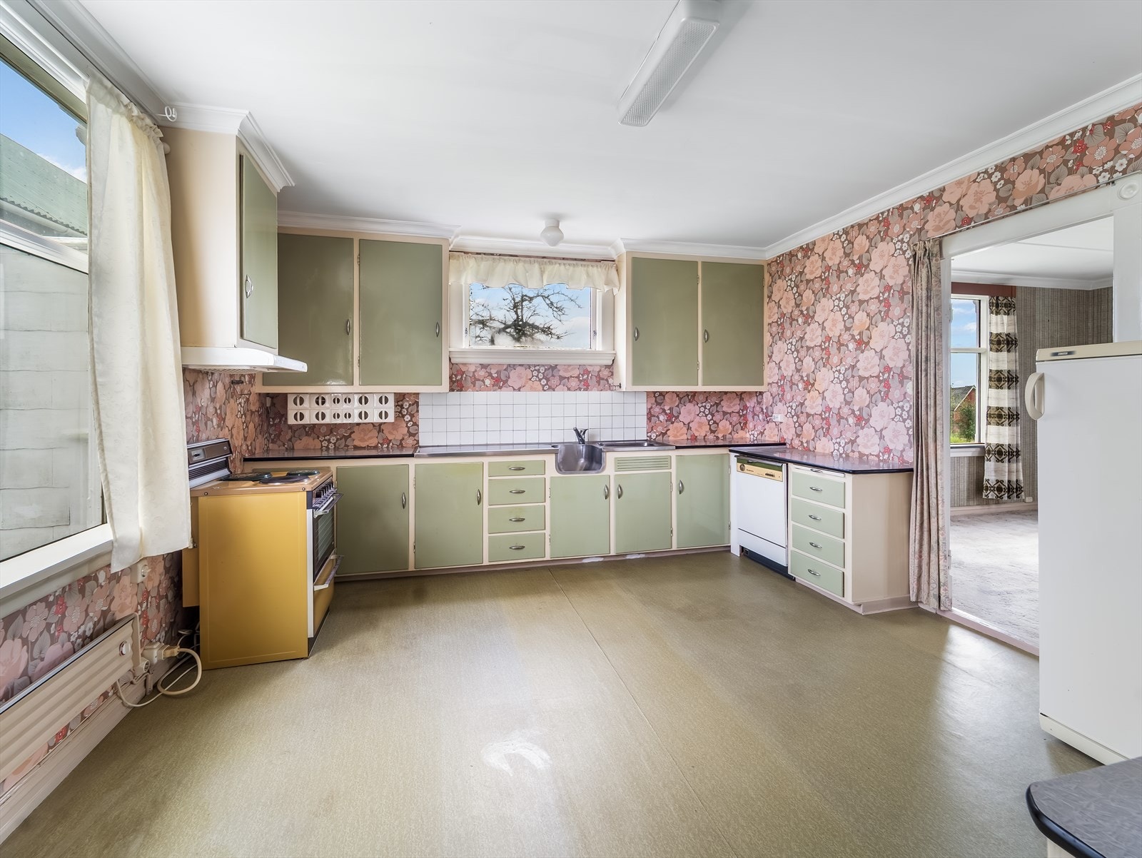 Eldre originalt kjøkken med oppmalt innredning og avsatt plass til hvitevarer. Galleribilde