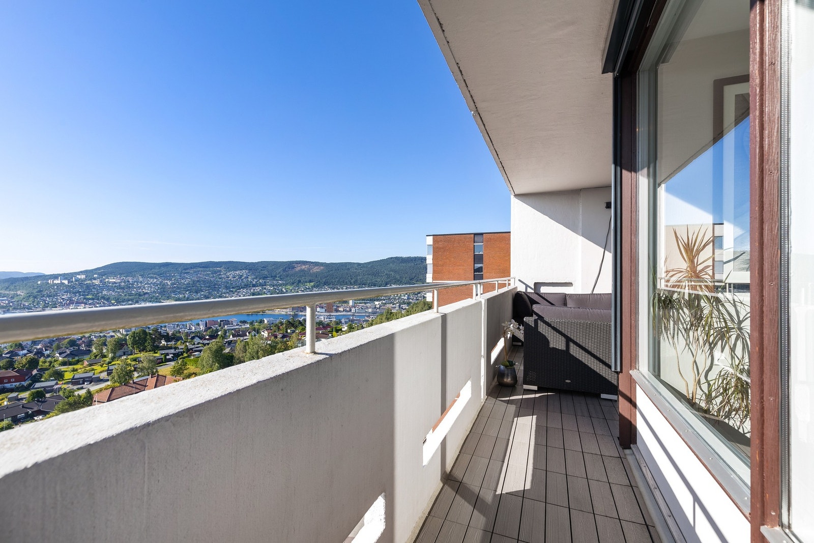 Balkongen har plastlammeller på gulv og rekkverk av mur og stål Galleribilde