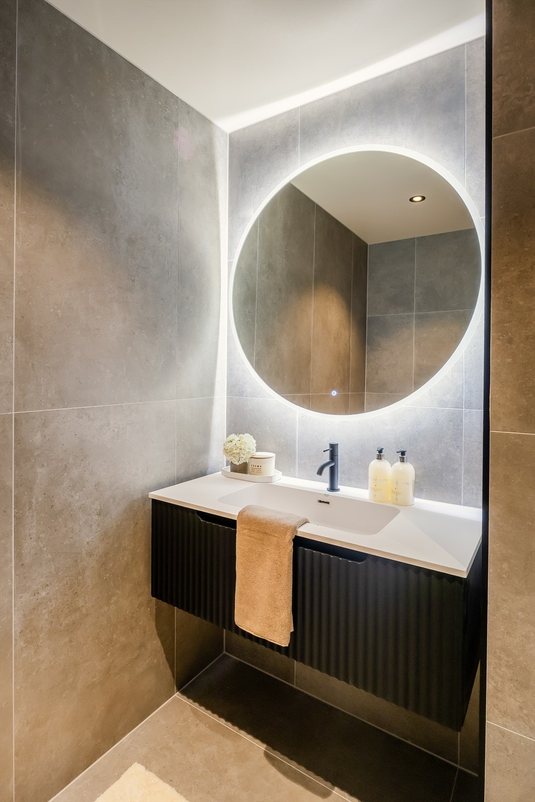 Det inneholder dusjvegg av glass og dusjgarnityr på vegg, vegghengt toalett, innredning med servant, opplegg for vaskemaskin (Kran og avløp). Galleribilde