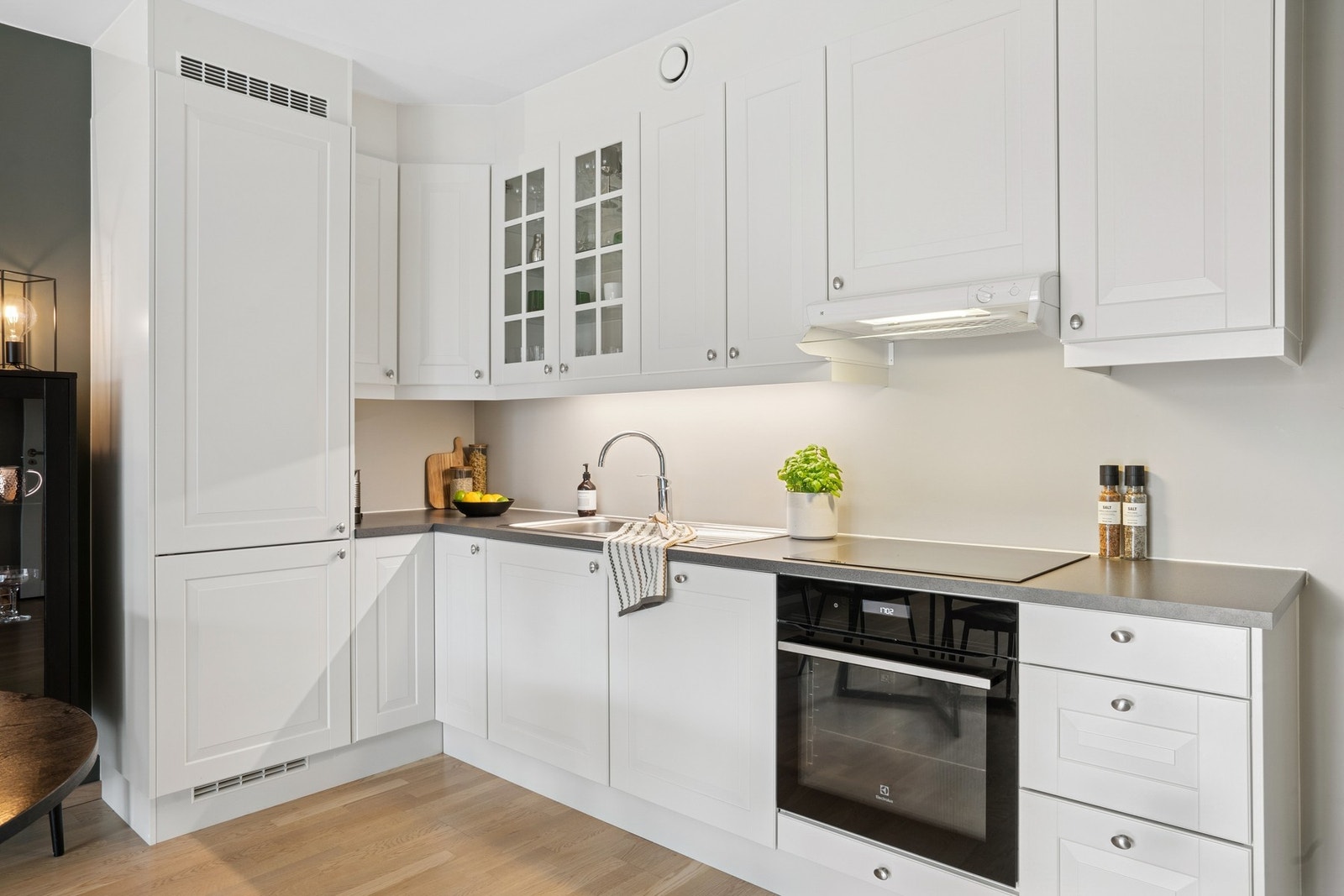 Kjøkken i åpen løsning med lyse fronter, godt med skapplass og integrerte hvitevarer. Galleribilde