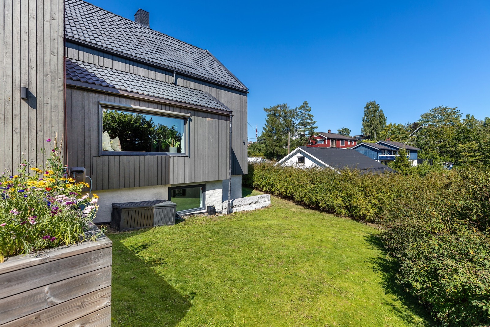 Den frodige hagen er innrammet av hekkbeplantning som skjerming mot øvrig bebyggelse. Galleribilde