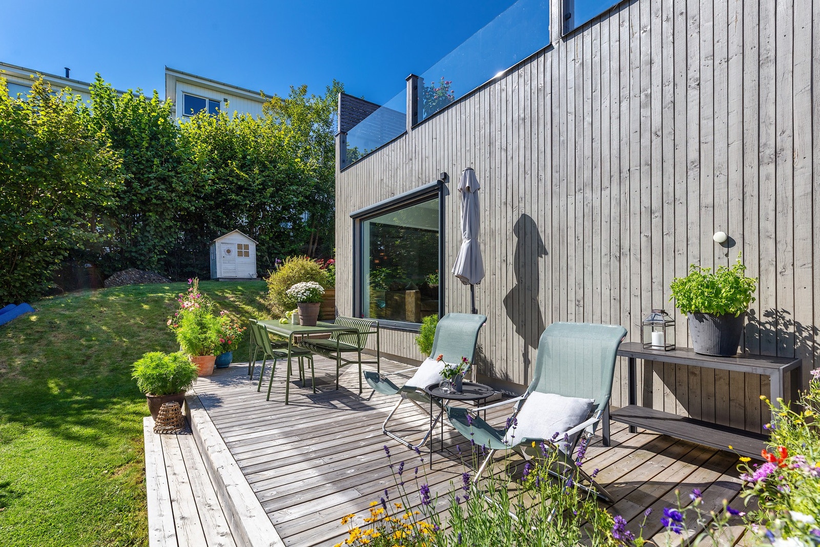 Uteplassen i trekonstruksjoner har bruksunderlag med terrassebord i tre. Galleribilde