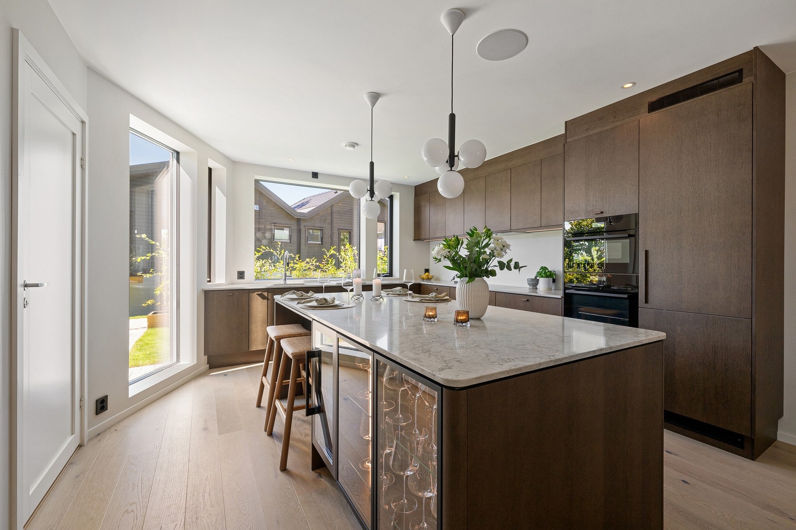 Her får man en svært påkostet kjøkkeninnredning fra Sigdal, levert med tidløse, slette fronter i Favn Nøtt finert eik og rene linjer som harmonerer perfekt med boligens moderne uttrykk. Galleribilde