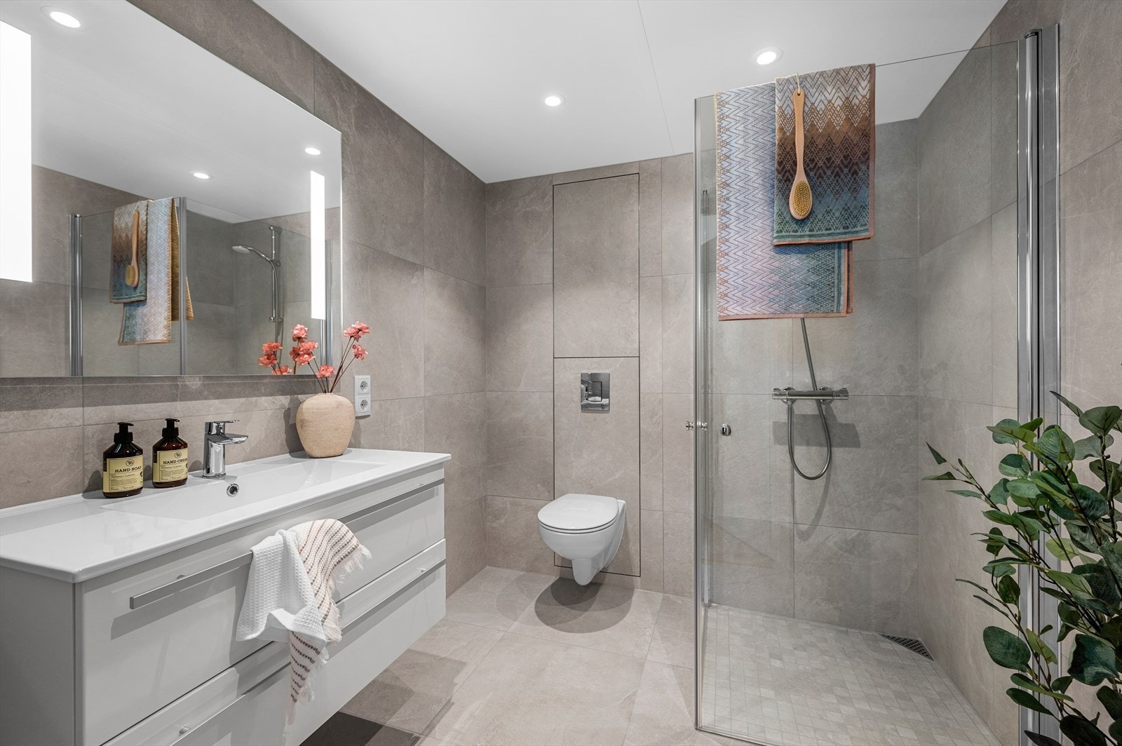 Leiligheten har to tilnærmet identiske bad med lekre påkostede 60x60 fliser og stilrent baderomsmøblement. Galleribilde