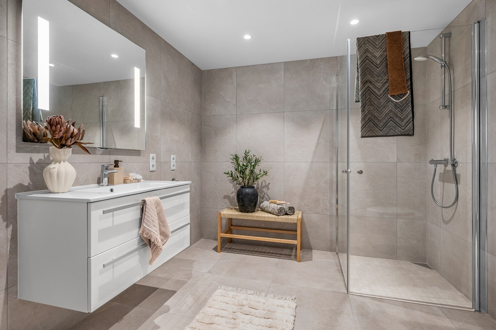 Hvert bad har vegghengt toalett, dusjhjørne med glassdører, downlights og gulvvarme. Dette har opplegg for vaskemaskin. Galleribilde