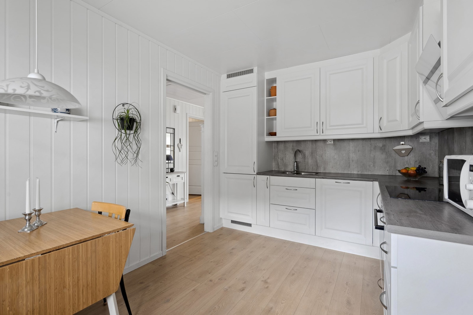 God skap- og skuffeinnredning fra tak til gulv, med integrerte hvitevarer. Galleribilde