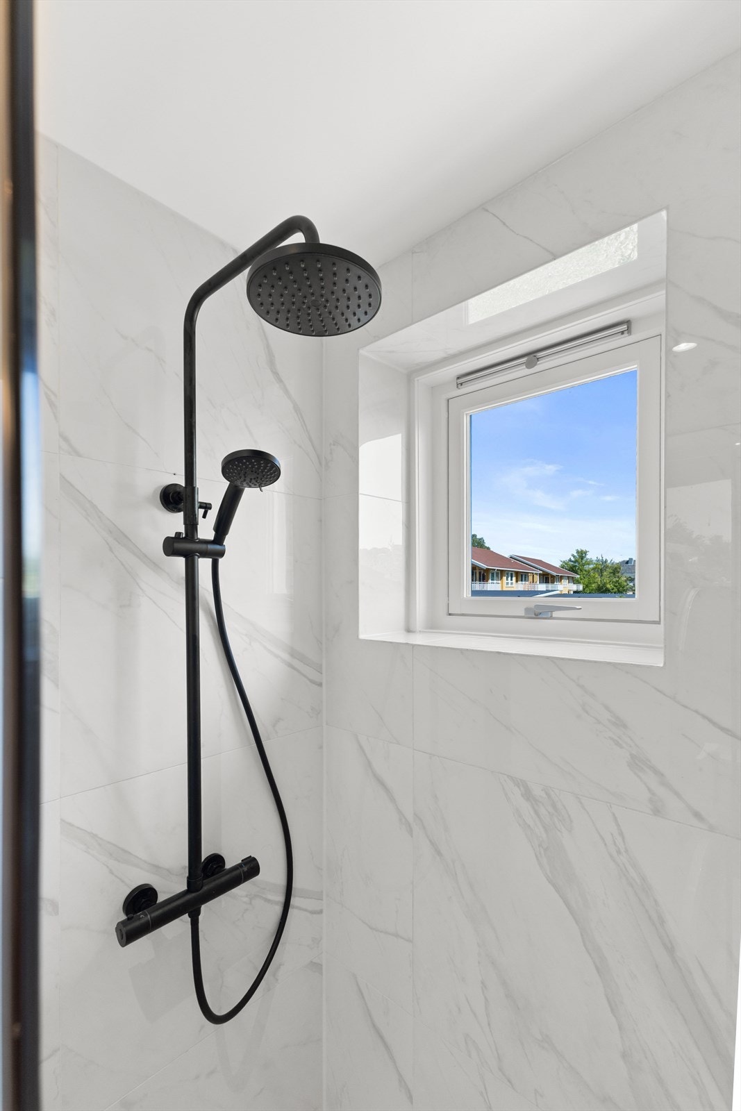 Badet har moderne og stilfulle fliser, behagelig gulvvarme og downlights i taket Galleribilde