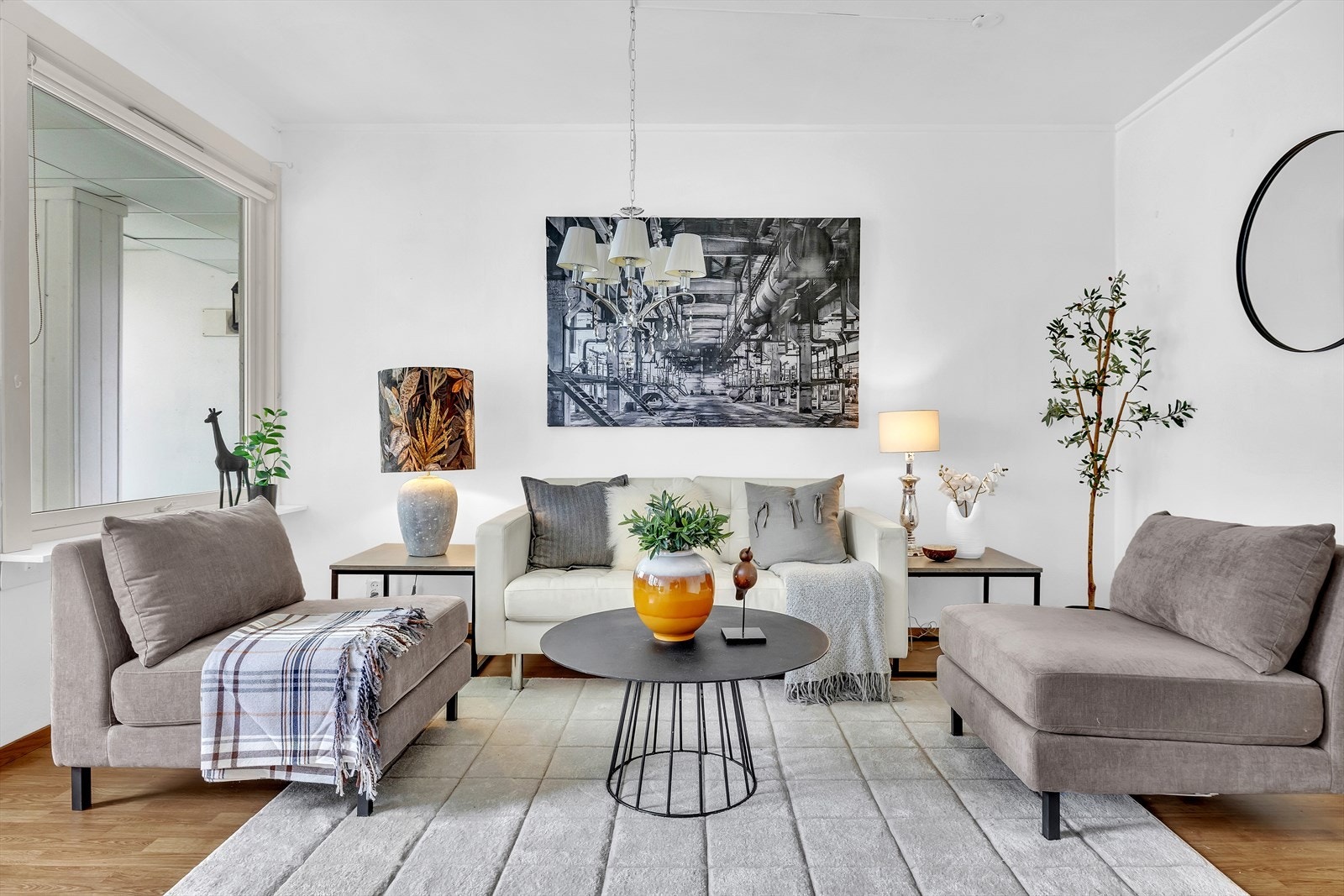 Laminatgulv og hvitmalte vegger gir et godt utgangspunkt for innredningen, og utformingen gjør stuen enkel å møblere med både spisebord og stor sofagruppe. Galleribilde
