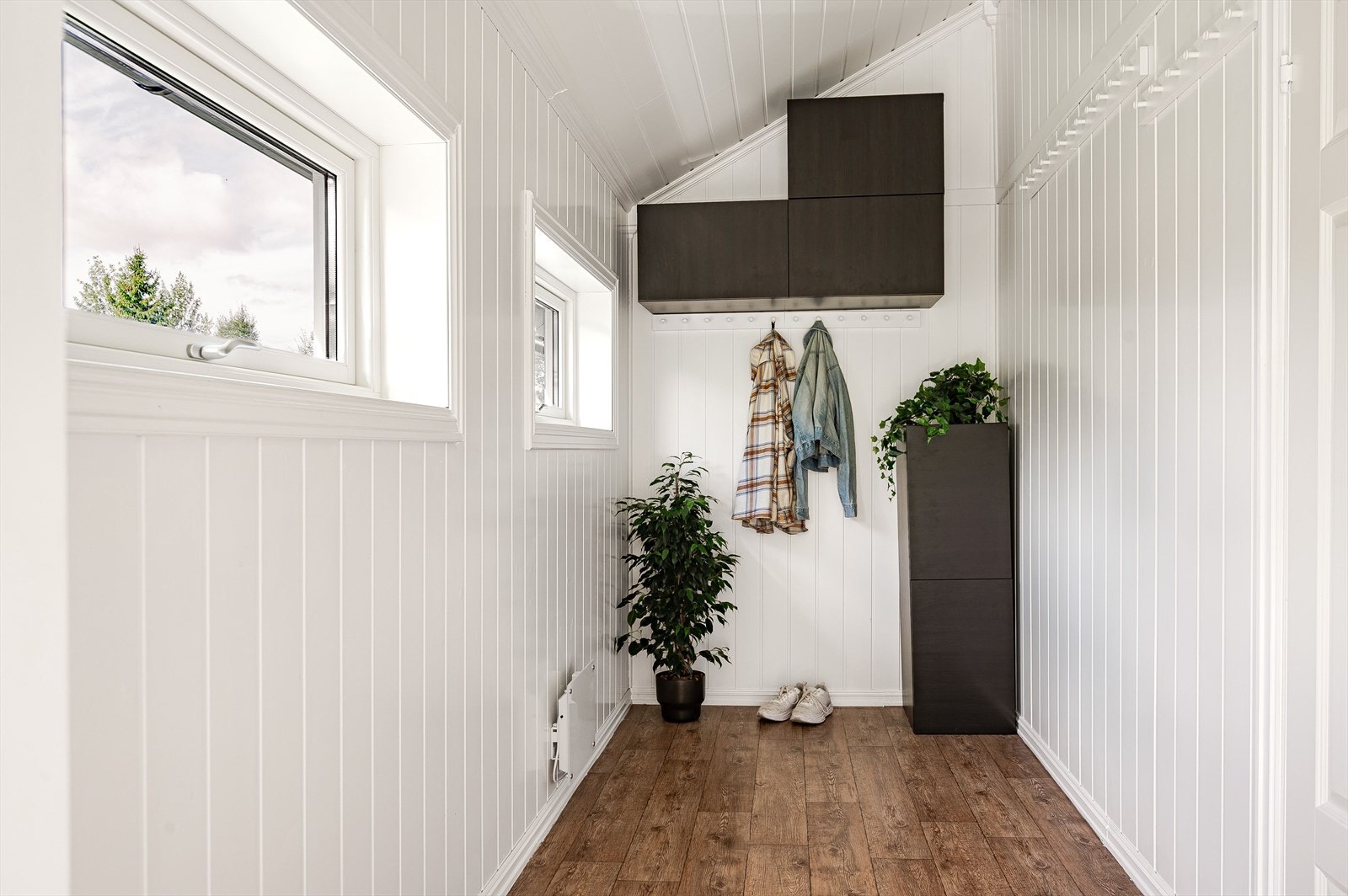 Velkommen inn! En lys og trivelig entré med opphengsmuligheter for tøy og vegghengte skap. Galleribilde