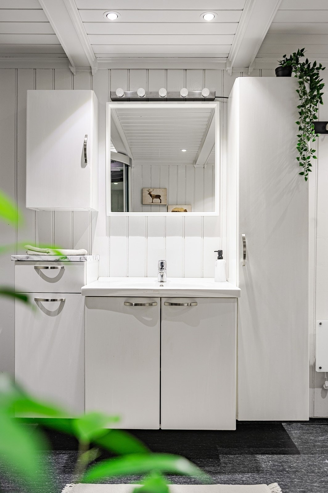 Badet er innredet med servant nedfelt i benkeskap, høyskap, overskap og skuffer. Videre er det belyst speil, dusjkabinett med massasjedyser og frittstående toalett. Galleribilde