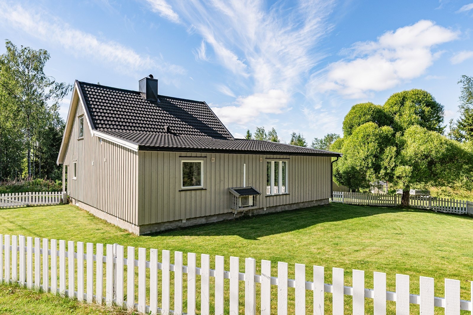 Den romslige hagen rundt store deler av boligen er innhegnet med hvitt gjerde. Galleribilde