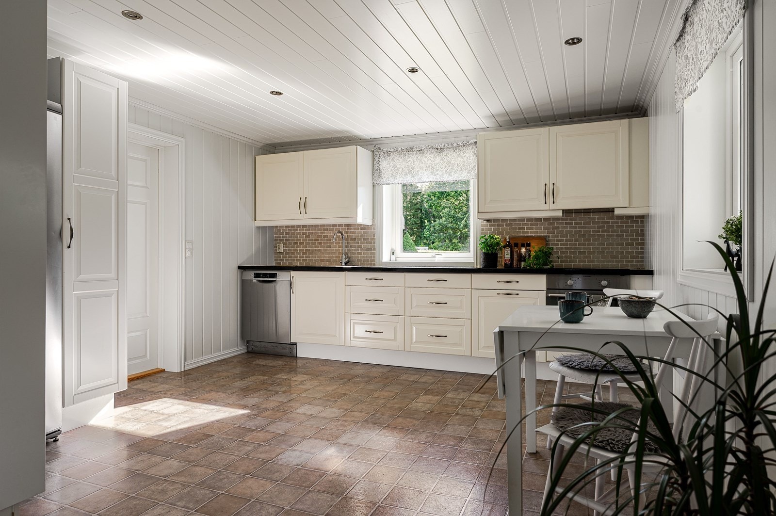 Nær entréen ligger kjøkkenet, som er av god størrelse og har innredning med profilerte fronter og heltre, foliert benkeplate. Integrert koketopp og stekeovn medfølger. Galleribilde