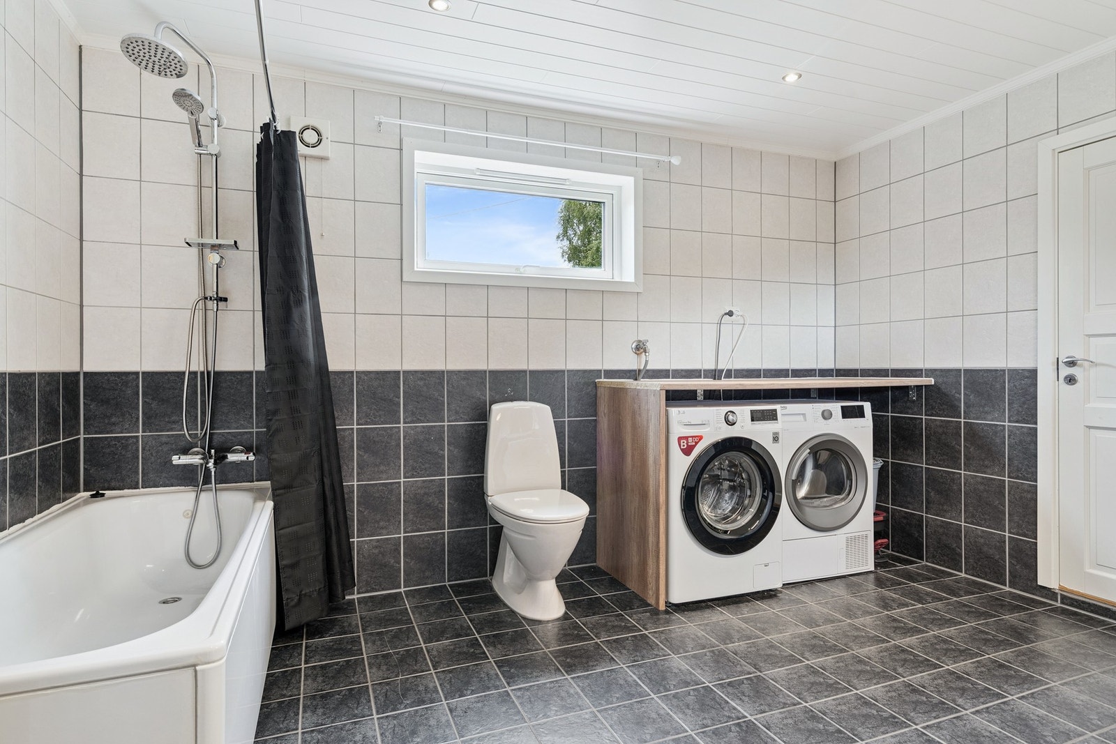 Badekar med dusjgarnityr, veggmontert wc, opplegg for vaskemaskin. Galleribilde