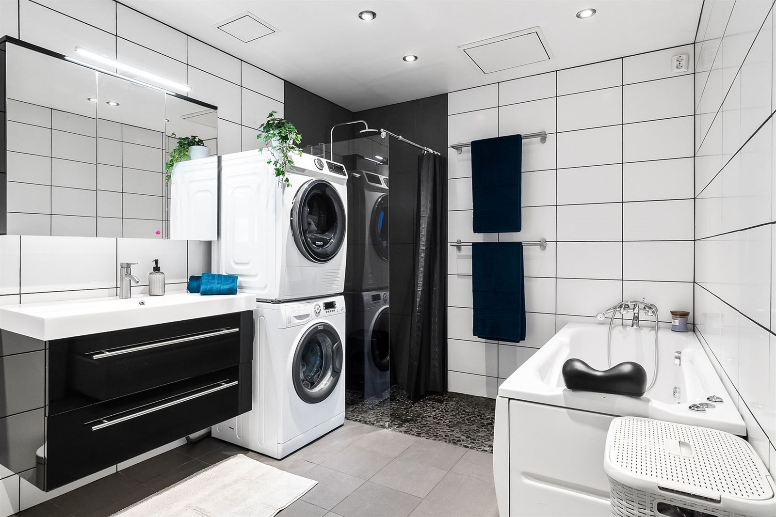 Baderom med dusj, badekar, servant, toalett og plass til vaskemaskin og tørketrommel. Galleribilde