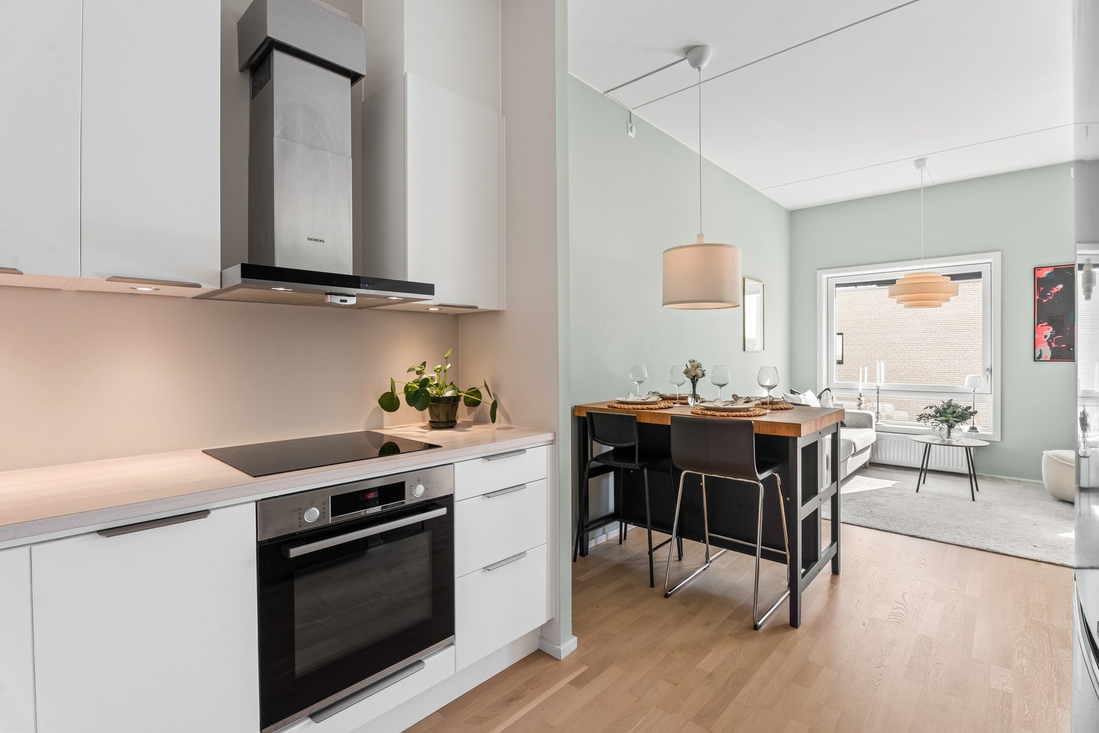 Kjøkkenet ligger i åpen løsning til stuen, men godt tilbaketrukket i en klart definert sone. I mellom de to sonene passer det utmerket å innrede med et spisebord. Galleribilde