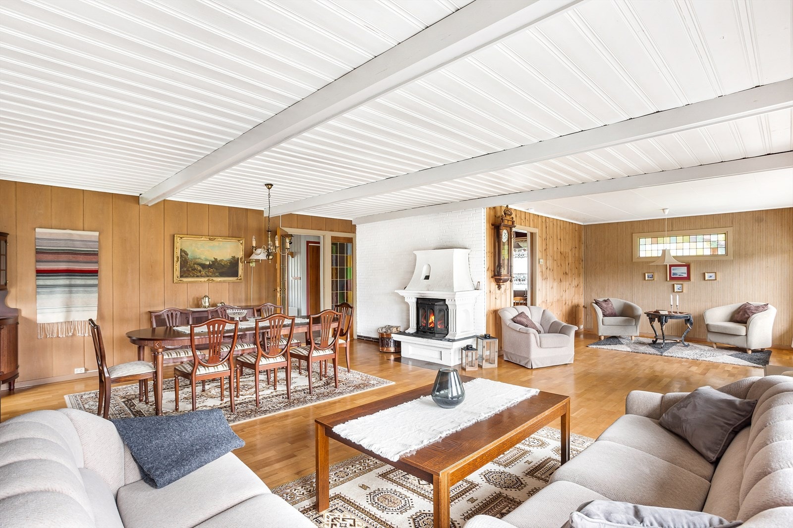 På gulvet er det parkett, mens veggene er kledd med trepanel og hvitmalt teglstein. Galleribilde