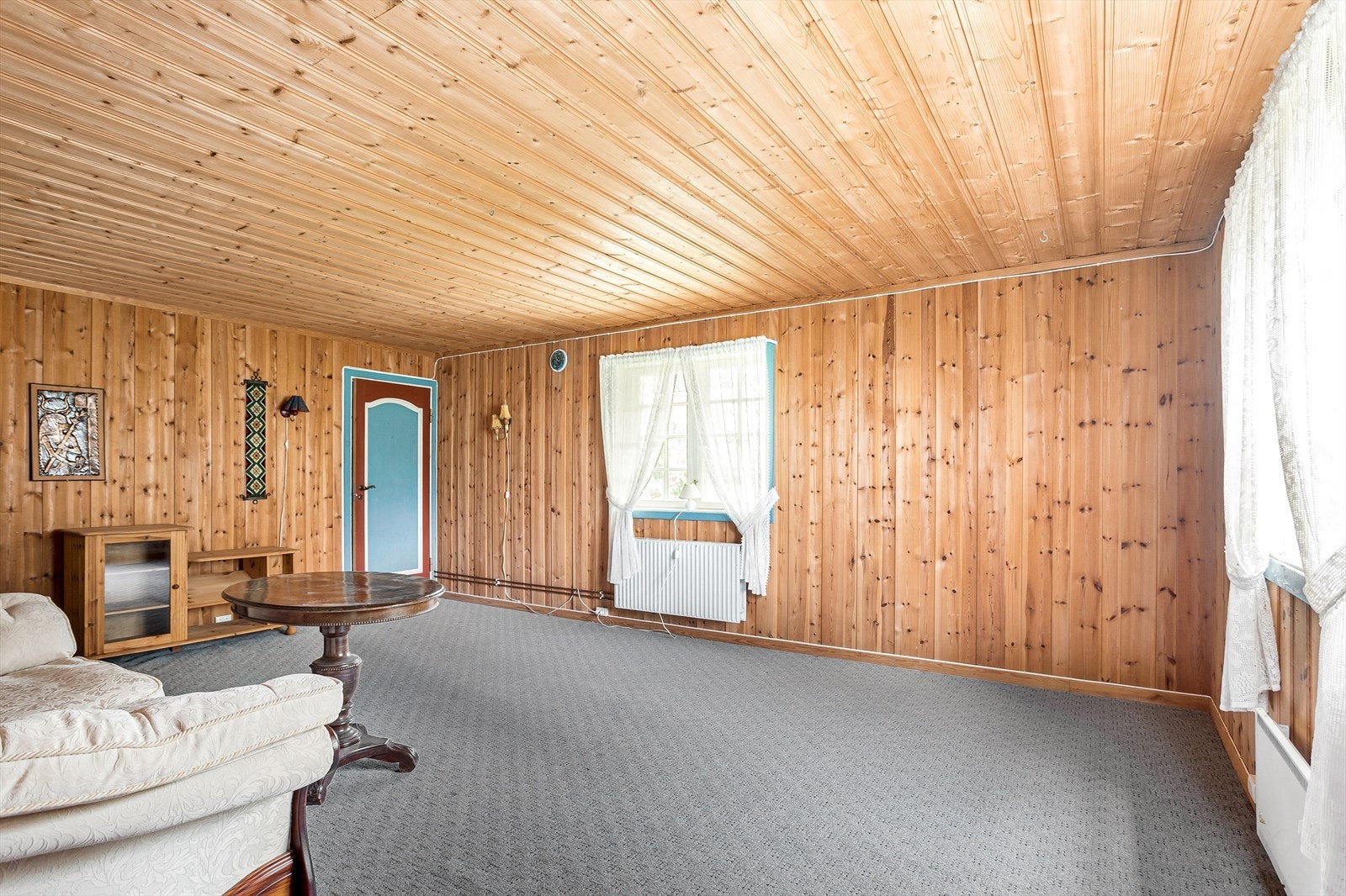 I kjelleretasjen har boligen et stort rom med teppegulv og panelvegger. Galleribilde