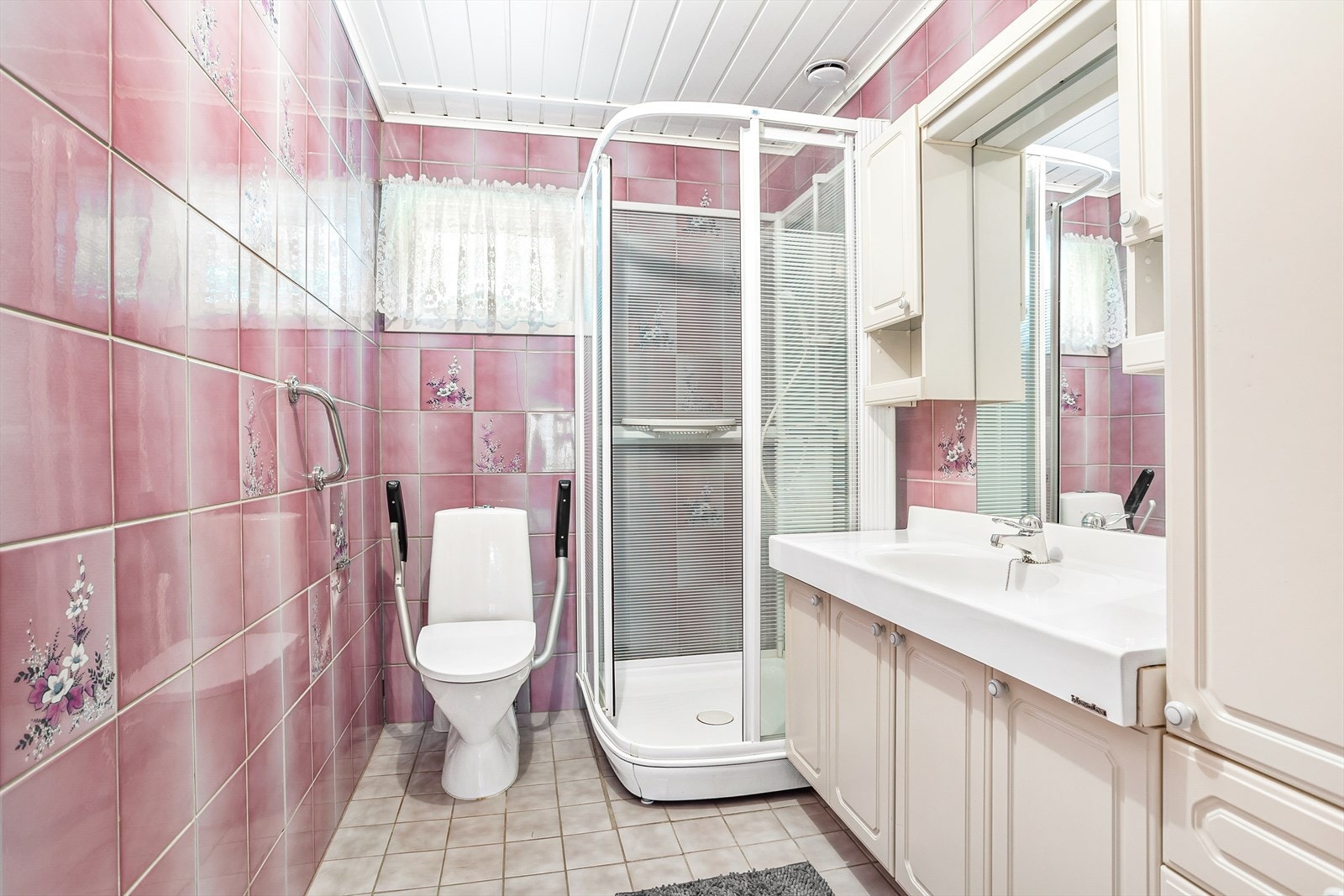 Boligen har bad i begge etasjer - dette i første etasje har lun gulvvarme, gulvmontert toalett og dusjkabinett.
Innredningen har heldekkende servant over skapseksjon, matchende høy- og veggskap, samt speil med belysning. Galleribilde