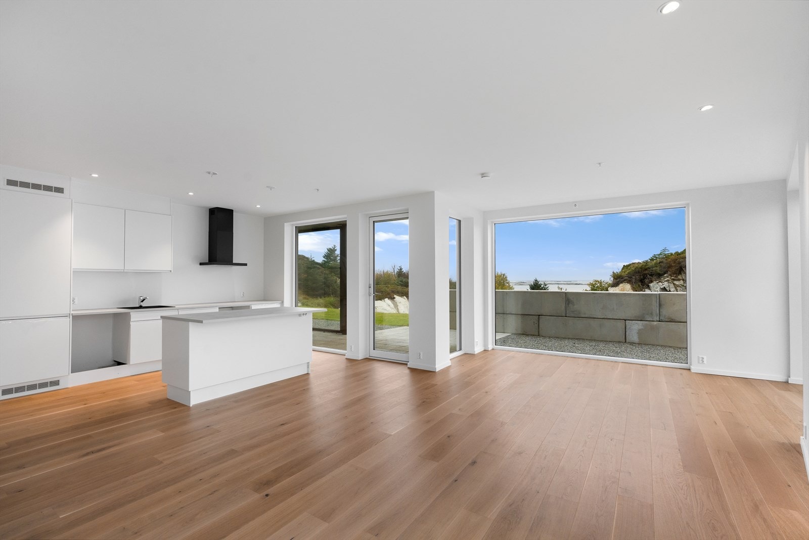 Flott en-stavs parkett, malte vegger og spotlights i himlingen gir kjøkkenet et moderne og stilrent uttrykk. Galleribilde