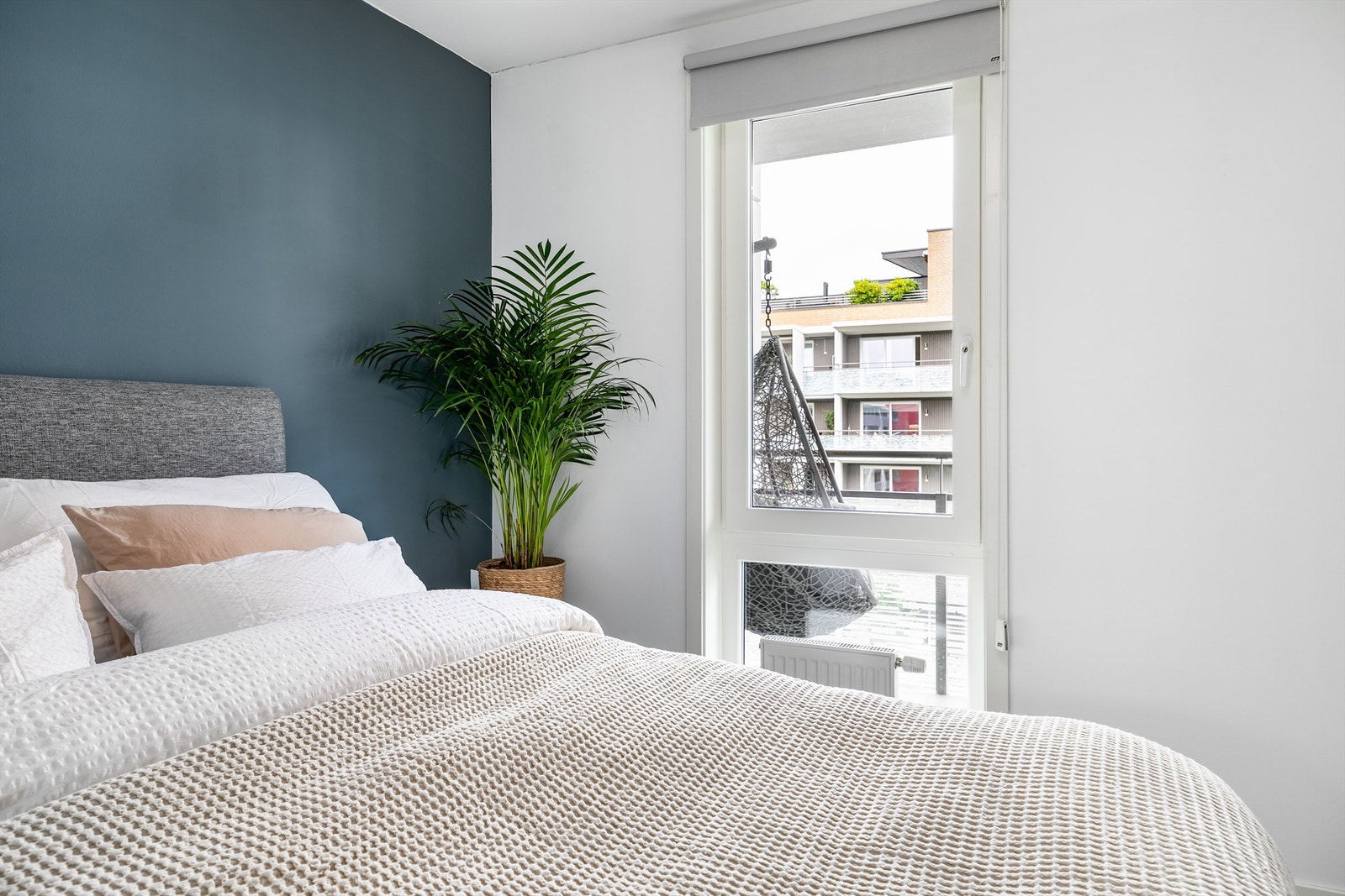 Lysblendende rullegardin er montert over soverommets vertikalstilte vindu, som ellers besørger gode lysforhold i rommet. Galleribilde