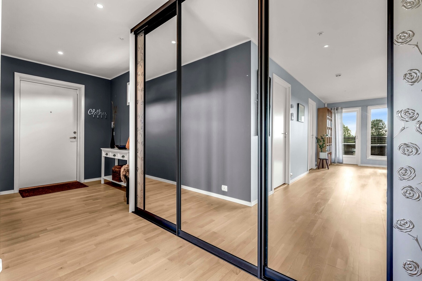 Romslig entré med stor skyvedørsgarderobe Galleribilde