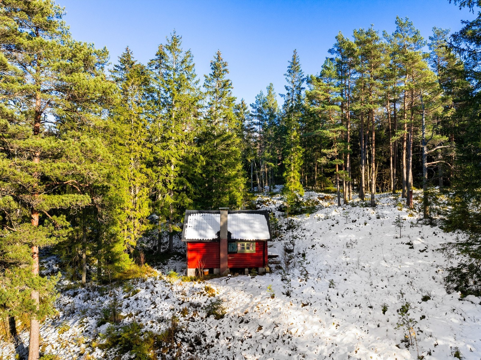 På en lysning i skogen ovenfor Glennetangen ligger denne lille og enkle hytta i laftet, rødmalt tømmer. Galleribilde