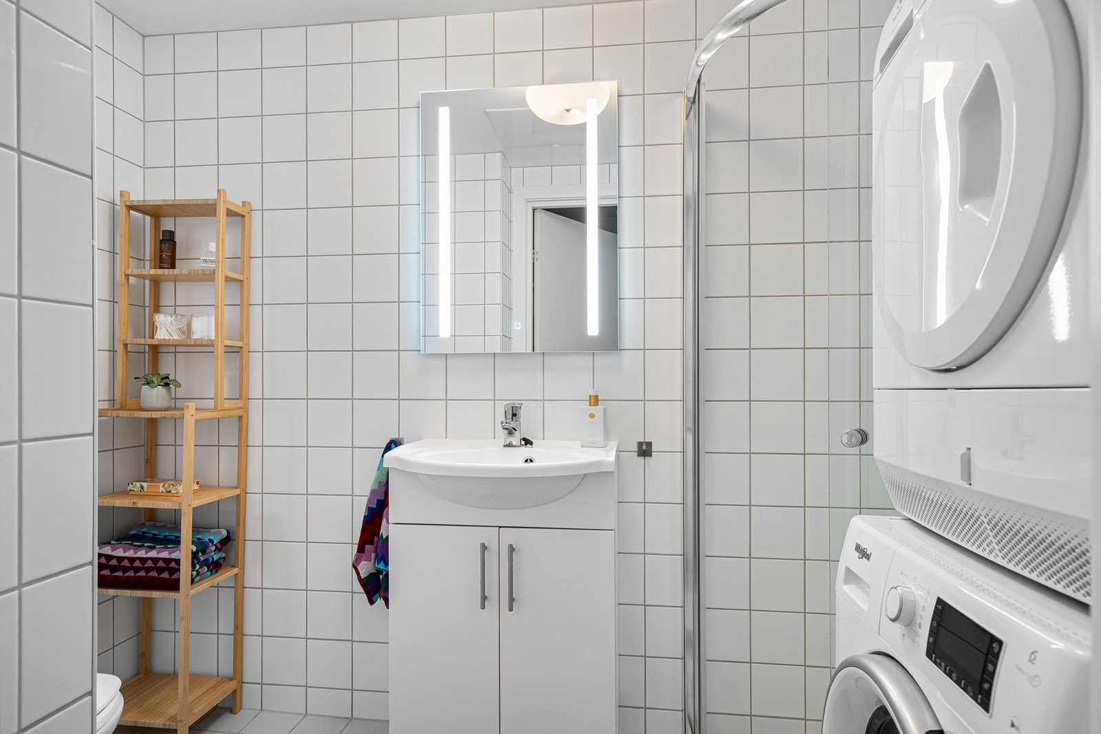 Flislagt baderom med "alt" du trenger. Her får du både dusjhjørne, klosett, servant, speilskap, opplegg til vaskemaskin og tørketrommel. Galleribilde