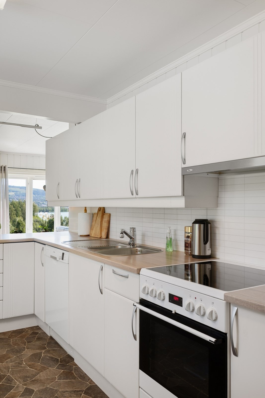 Kjøkkeninnredning med laminerte skrog, glatte fronter og laminert benkeplate med kjøkkenkum. Galleribilde