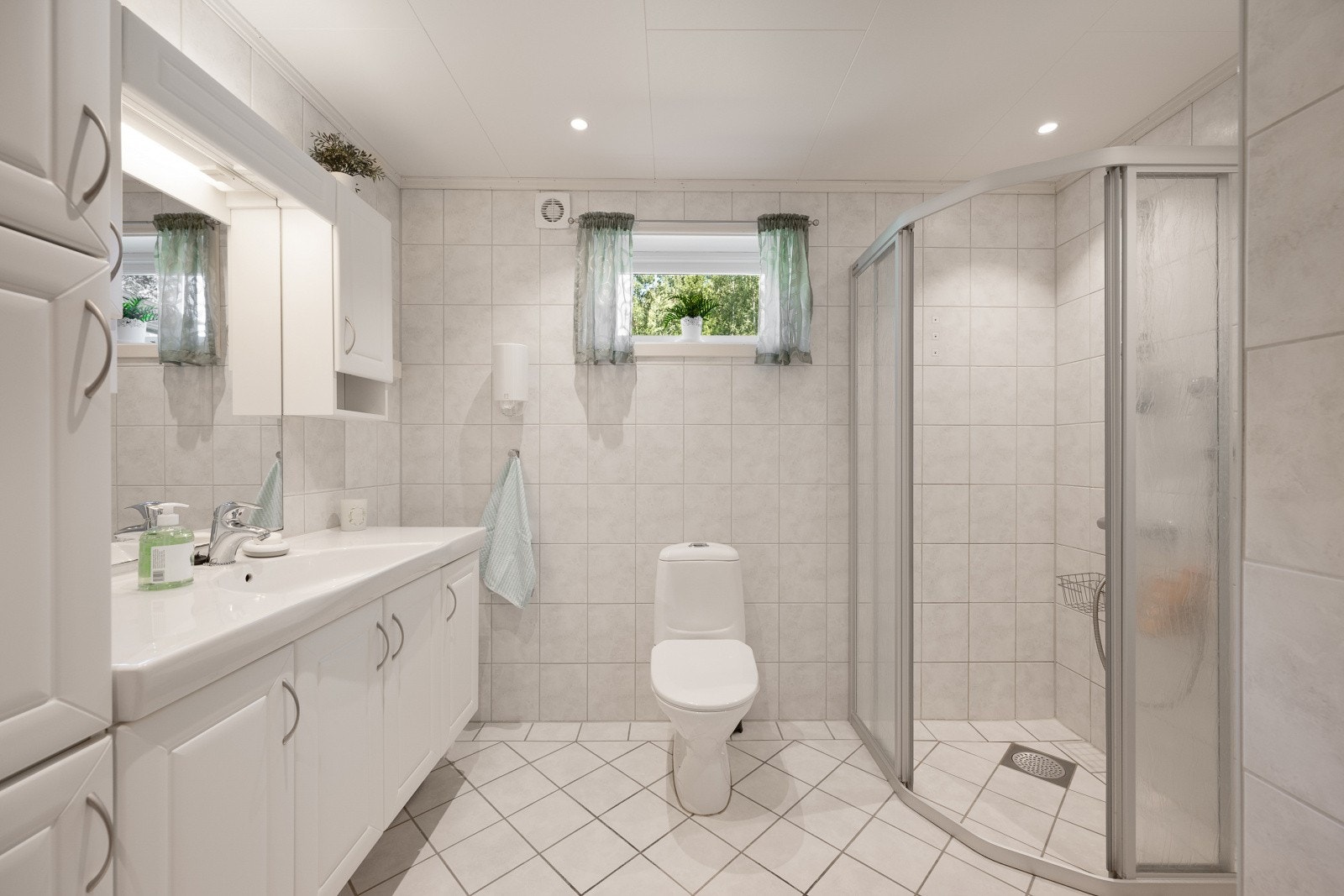 Helfliset baderom med gulvvarme. Servant med underskap. Speil med tilhørende belysning. Dusjvegger.
Gulvmontert wc. Mekanisk avtrekk. Tilluft i dør. Galleribilde