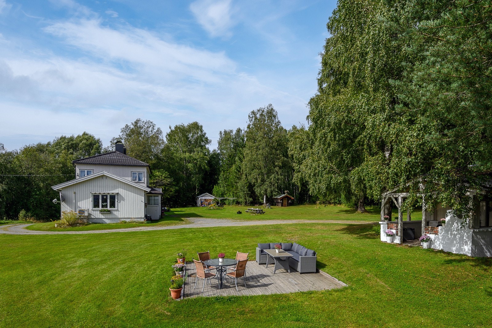 Flat tomt som er pen opparbeidet med plen og flere soner for rekreasjon. Galleribilde