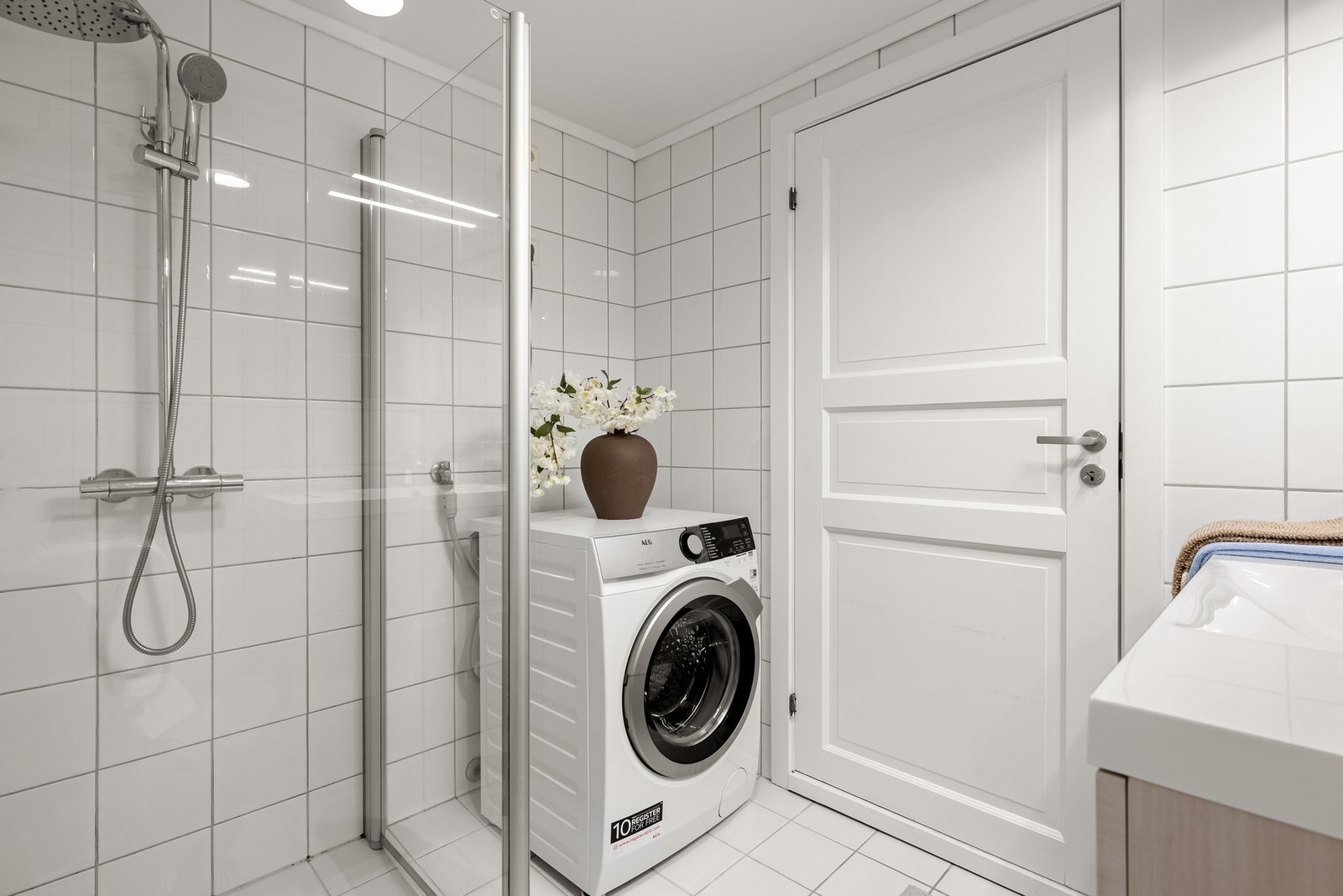 Badet er innredet med toalett, dusjhjørne med dusjgarnityr og baderomsmøblement med servant, speil og belysning. Galleribilde