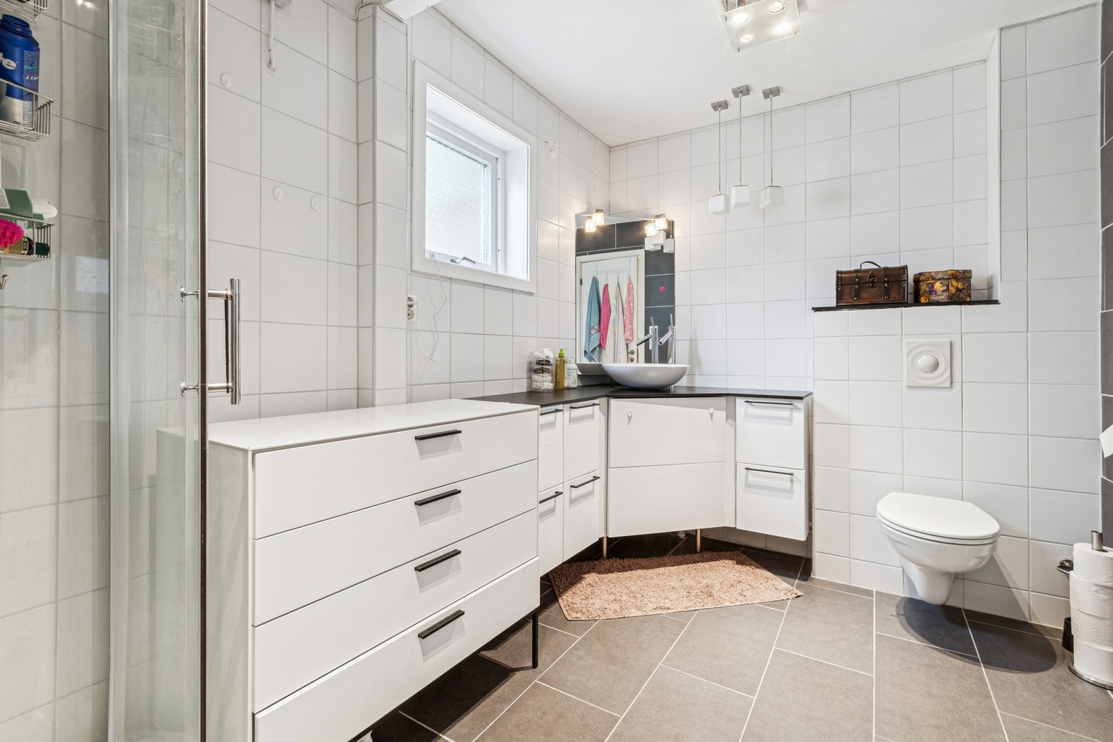 Badet i 1.etasje har flislagt gulv med varmekabler og fliser på vegg. Galleribilde