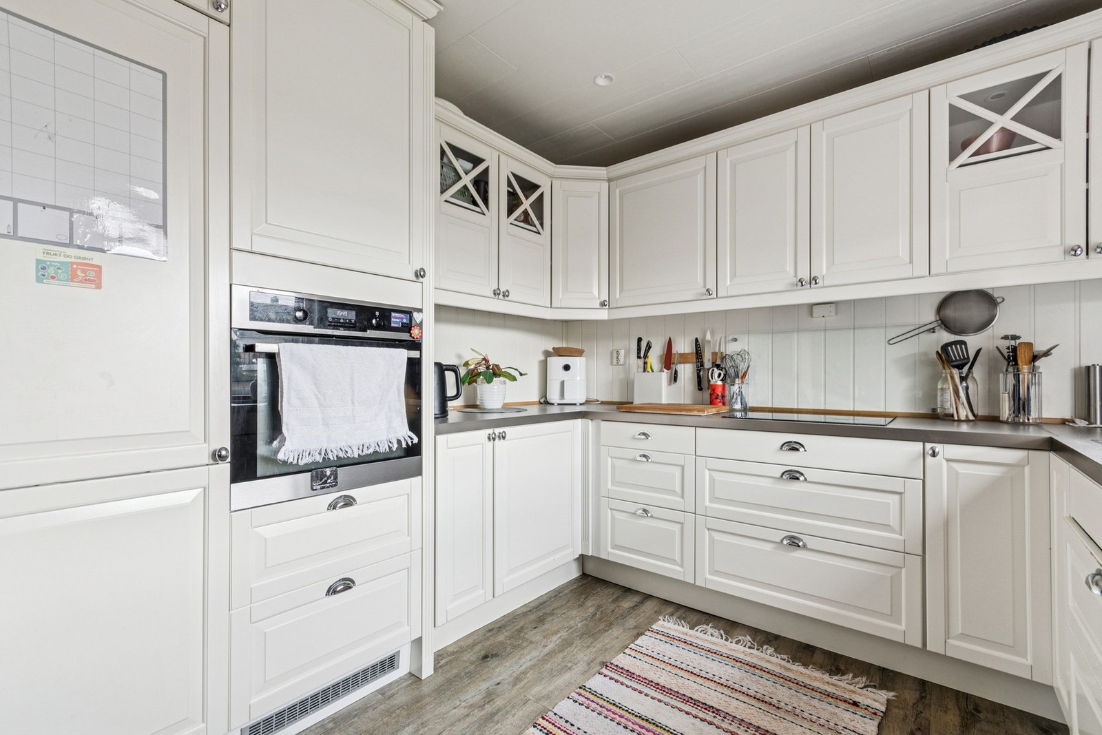 Integrerte hvitevarer som platetopp, stekeovn og kjøleskap. Mekanisk avtrekk fra kjøkkenvifte Galleribilde