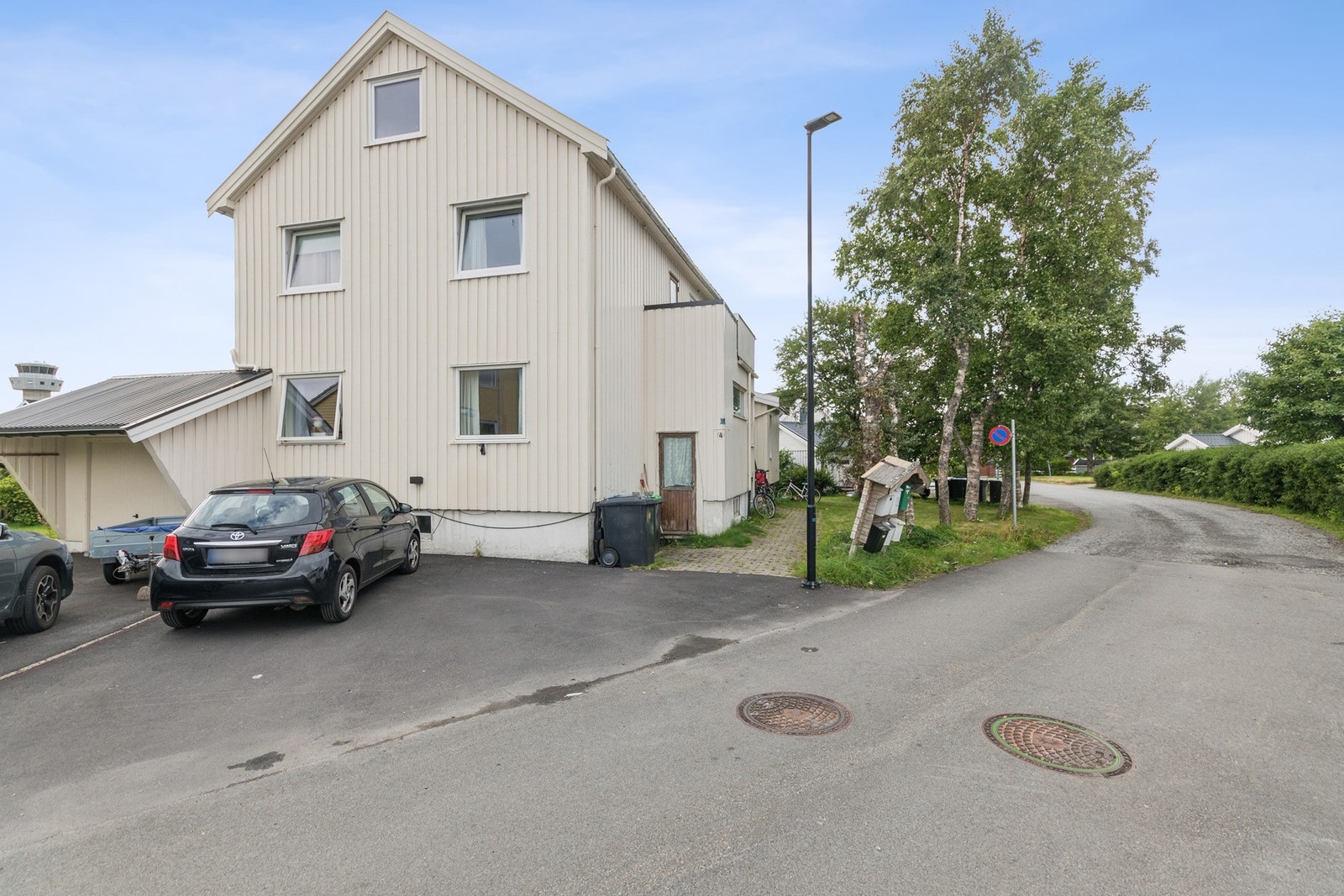 Internfordelt parkering på asfaltert gårdsplass med plass til to biler. Elbillader. Galleribilde